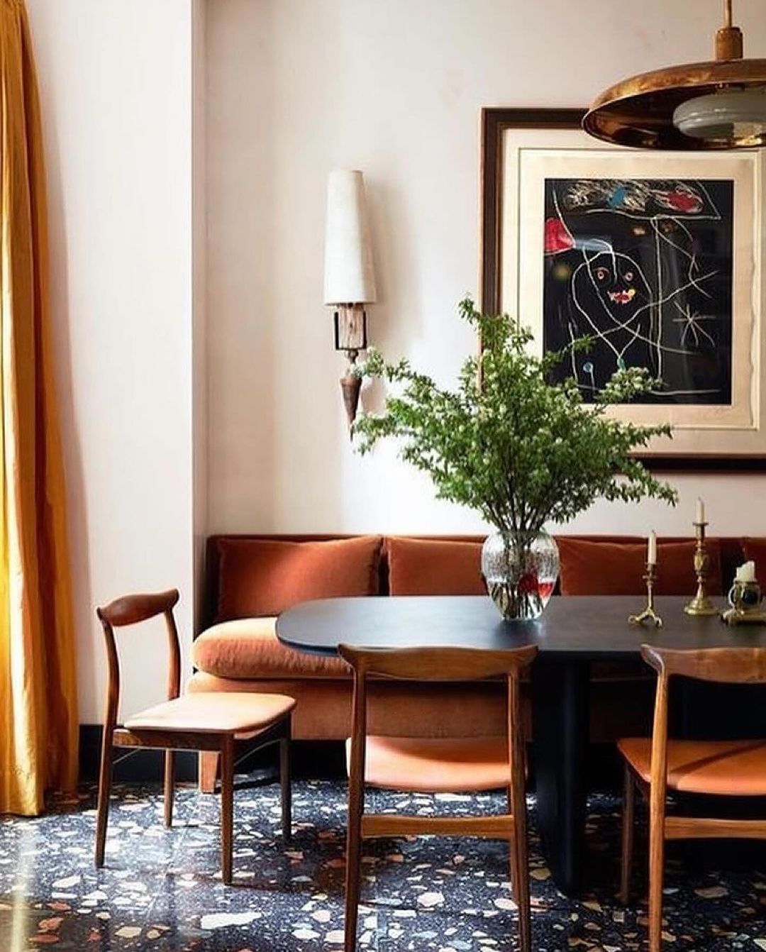 A chic and inviting dining space with a plush burnt orange corner sofa