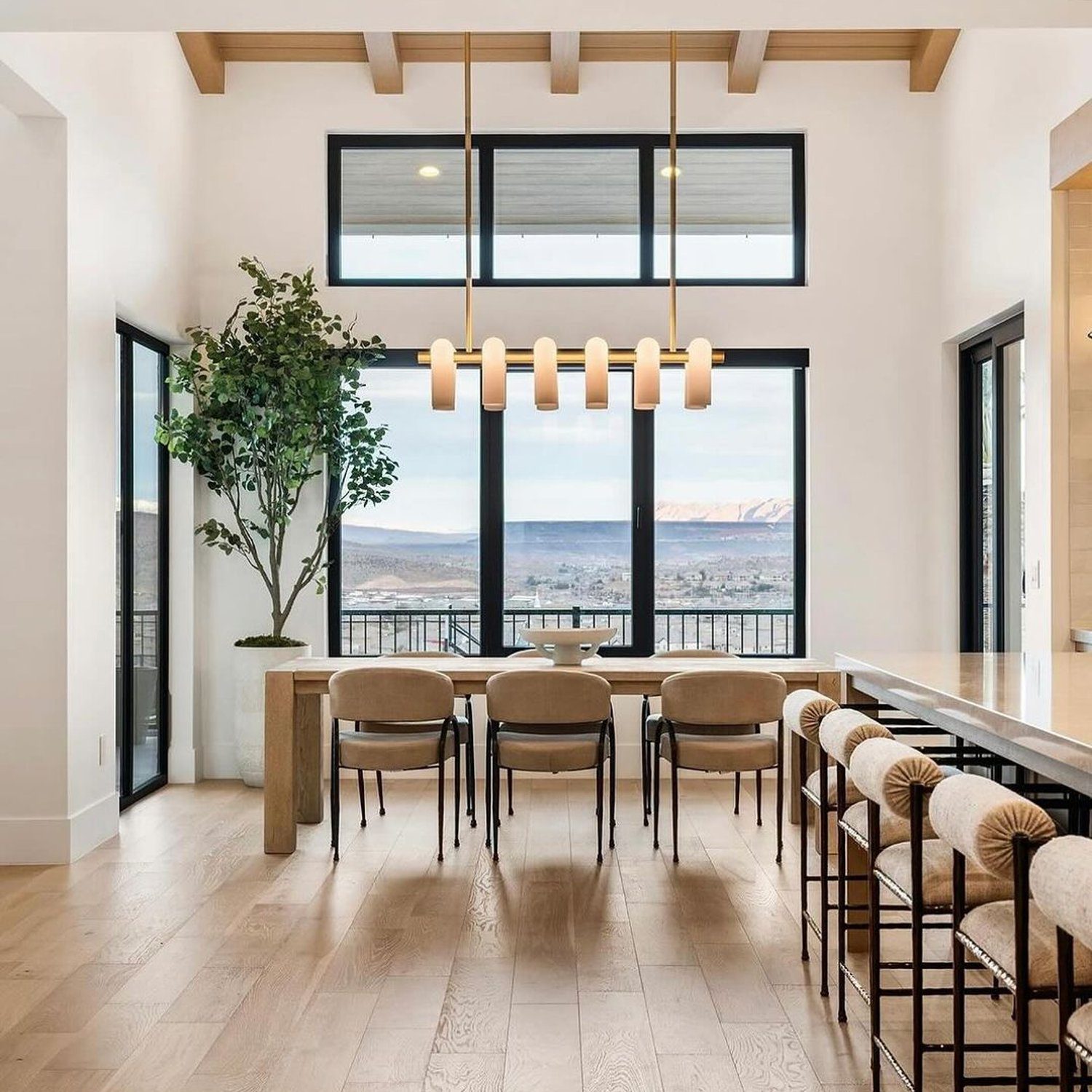 A spacious and bright dining area with large windows revealing an expansive view