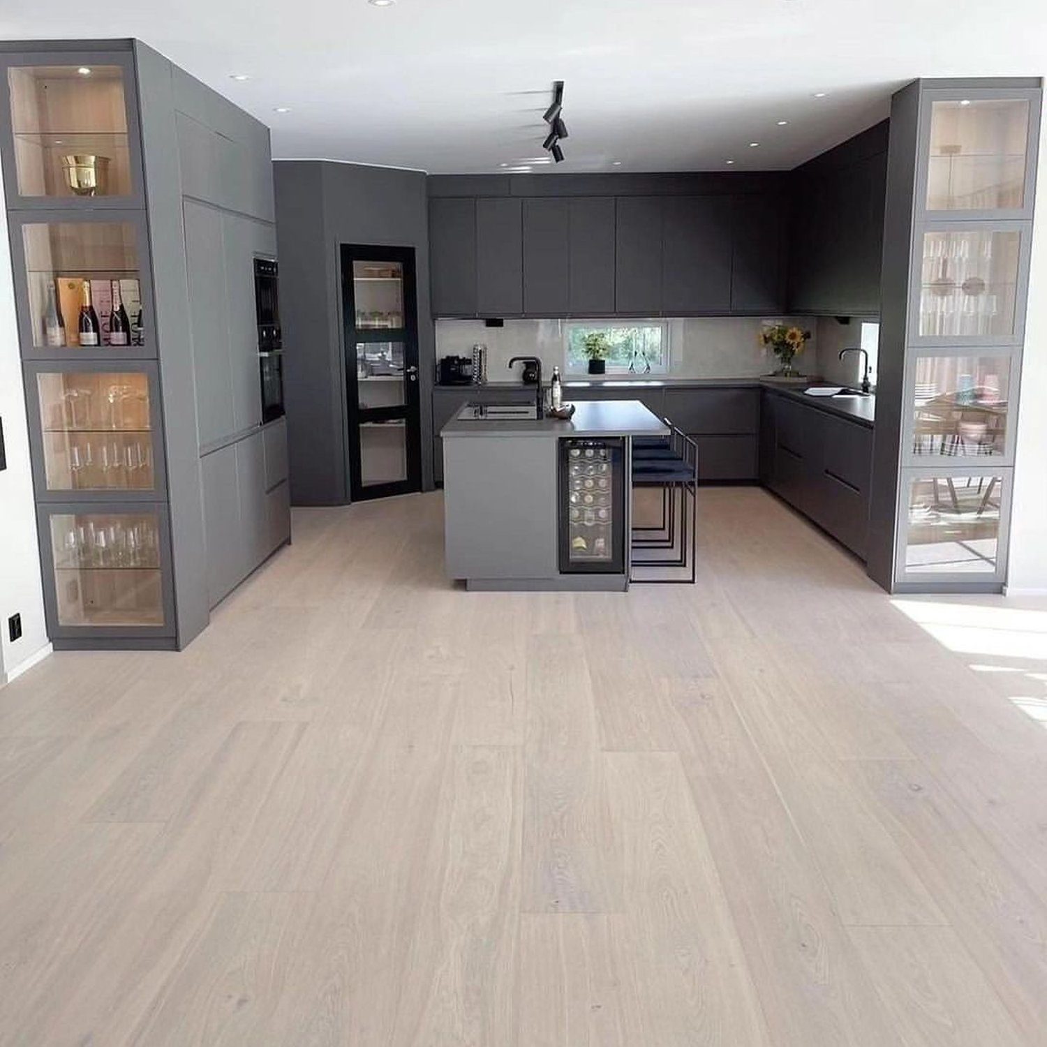 A modern kitchen with sleek grey cabinetry and integrated appliances