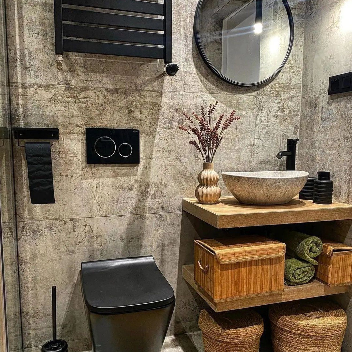 A stylish and contemporary bathroom design featuring industrial grey textured walls, a modular wooden vanity with woven baskets, a chic stone basin, and modern matte black fixtures.