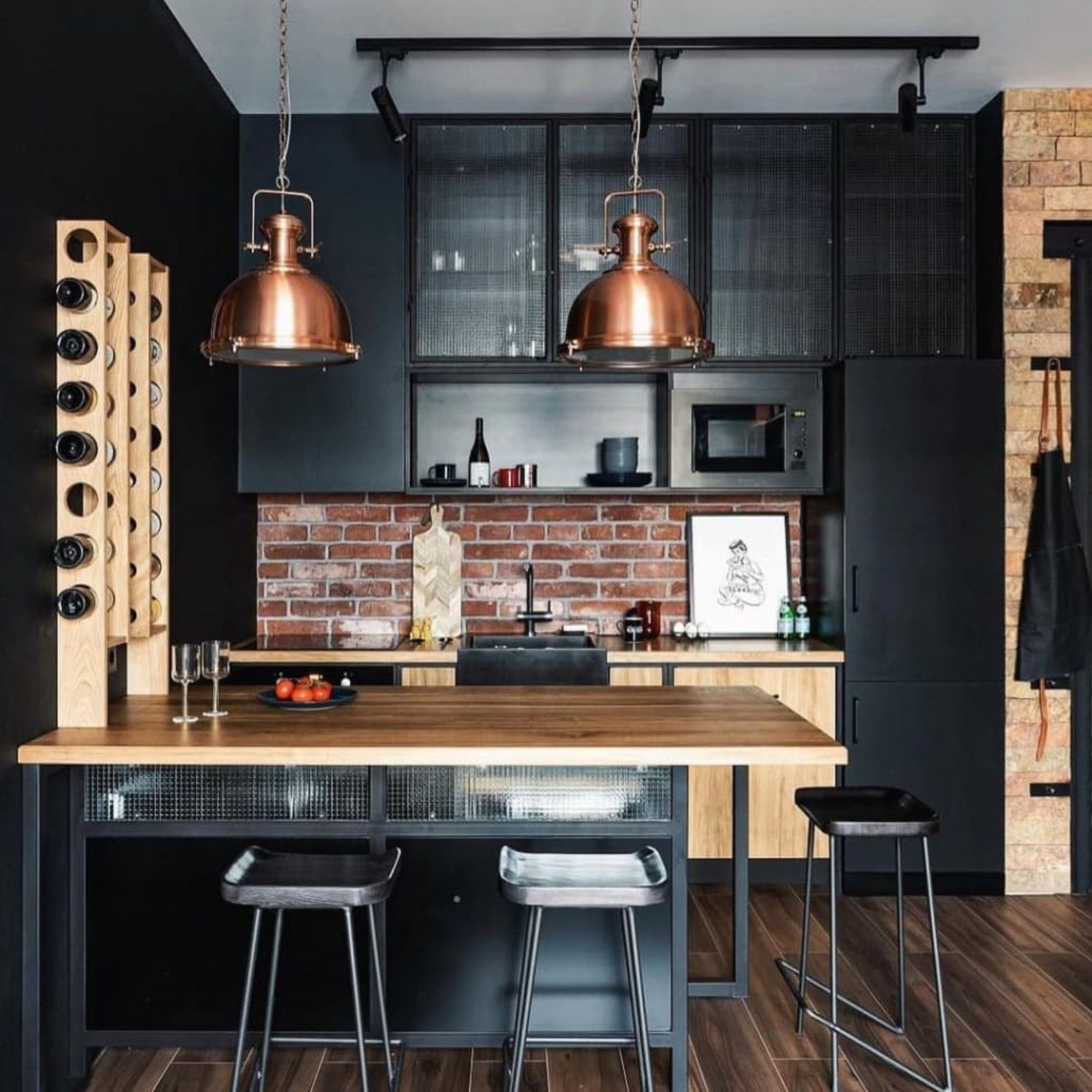 A modern kitchen with industrial flair featuring copper pendant lights and a brick backsplash.