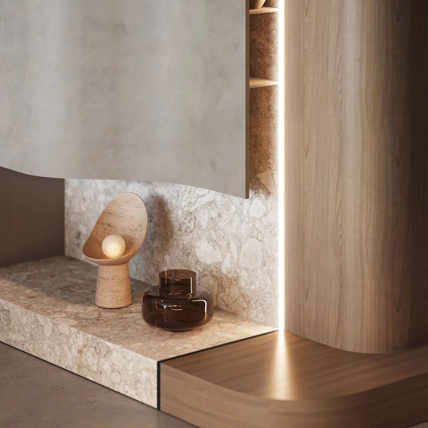 A tastefully appointed niche featuring a combination of materials with a minimalist lamp and amber glass accessories.