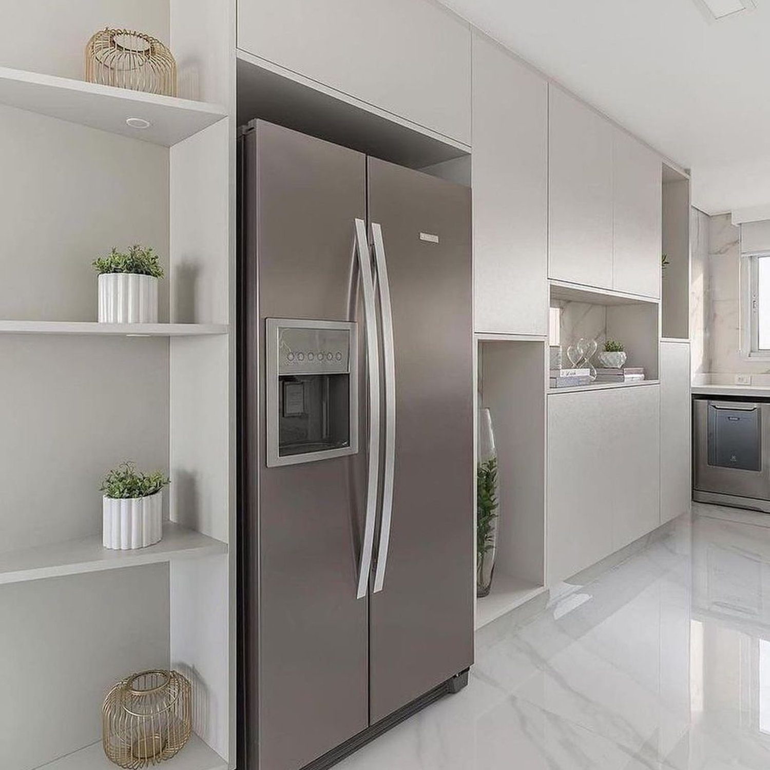 A sleek and modern kitchen featuring a stainless steel refrigerator, white cabinetry, and decorative greenery