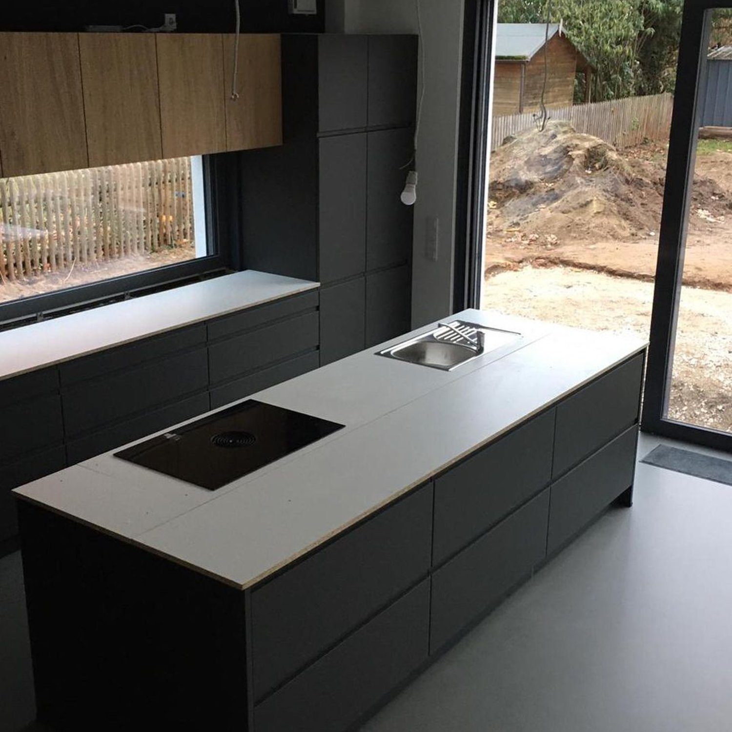 A modern kitchen featuring sleek dark cabinetry