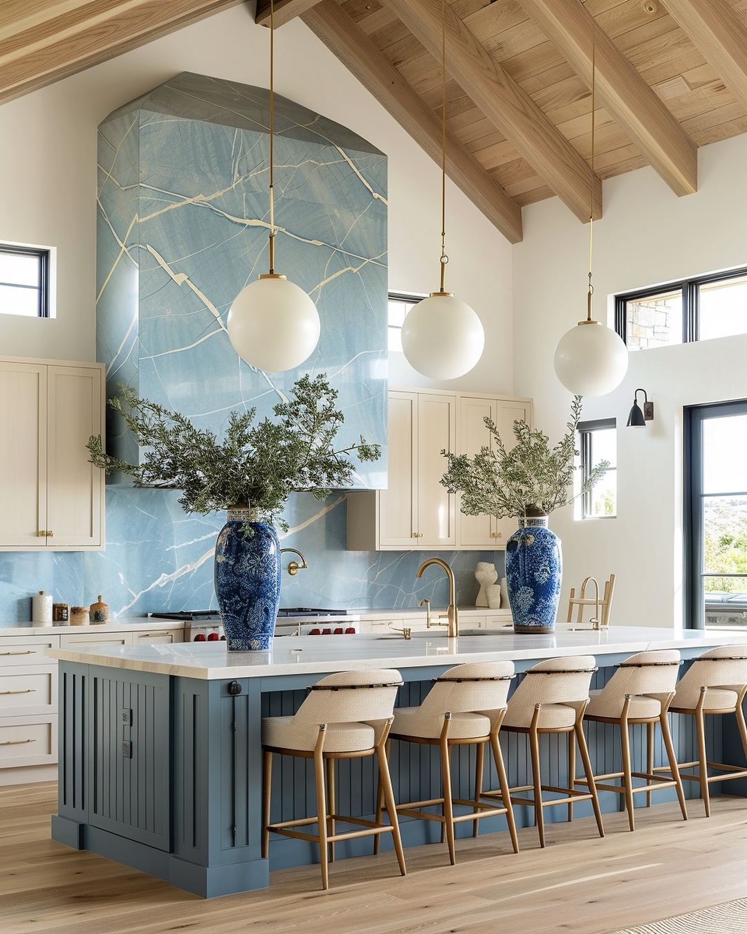 A modern kitchen with blue and beige tones, featuring a striking blue marble backsplash