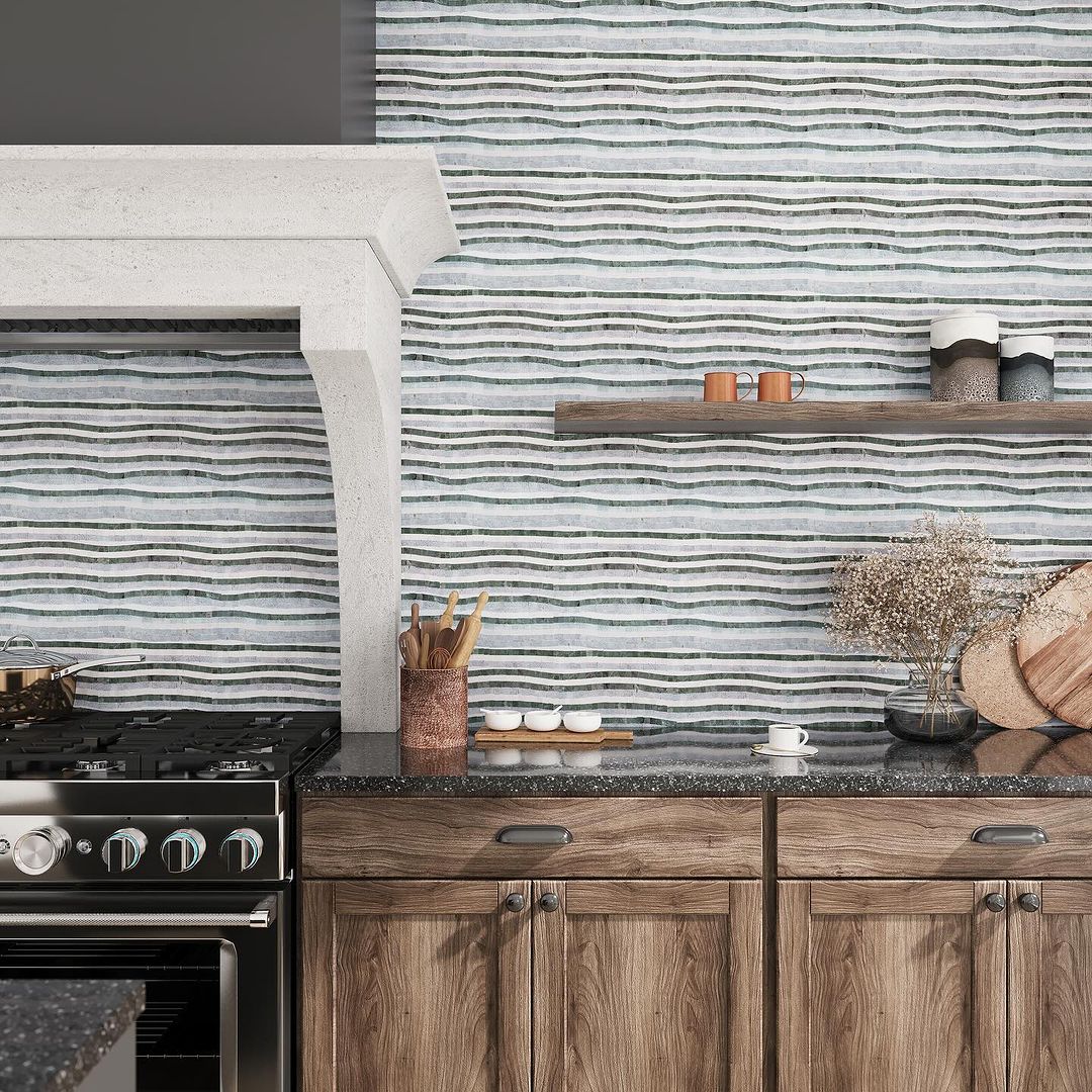 A modern kitchen featuring sculpted blue and white wavy backsplash tiles, concrete-style countertops, and rustic wooden cabinetry