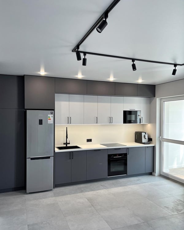 Sleek and modern kitchen design with track lighting and integrated appliances