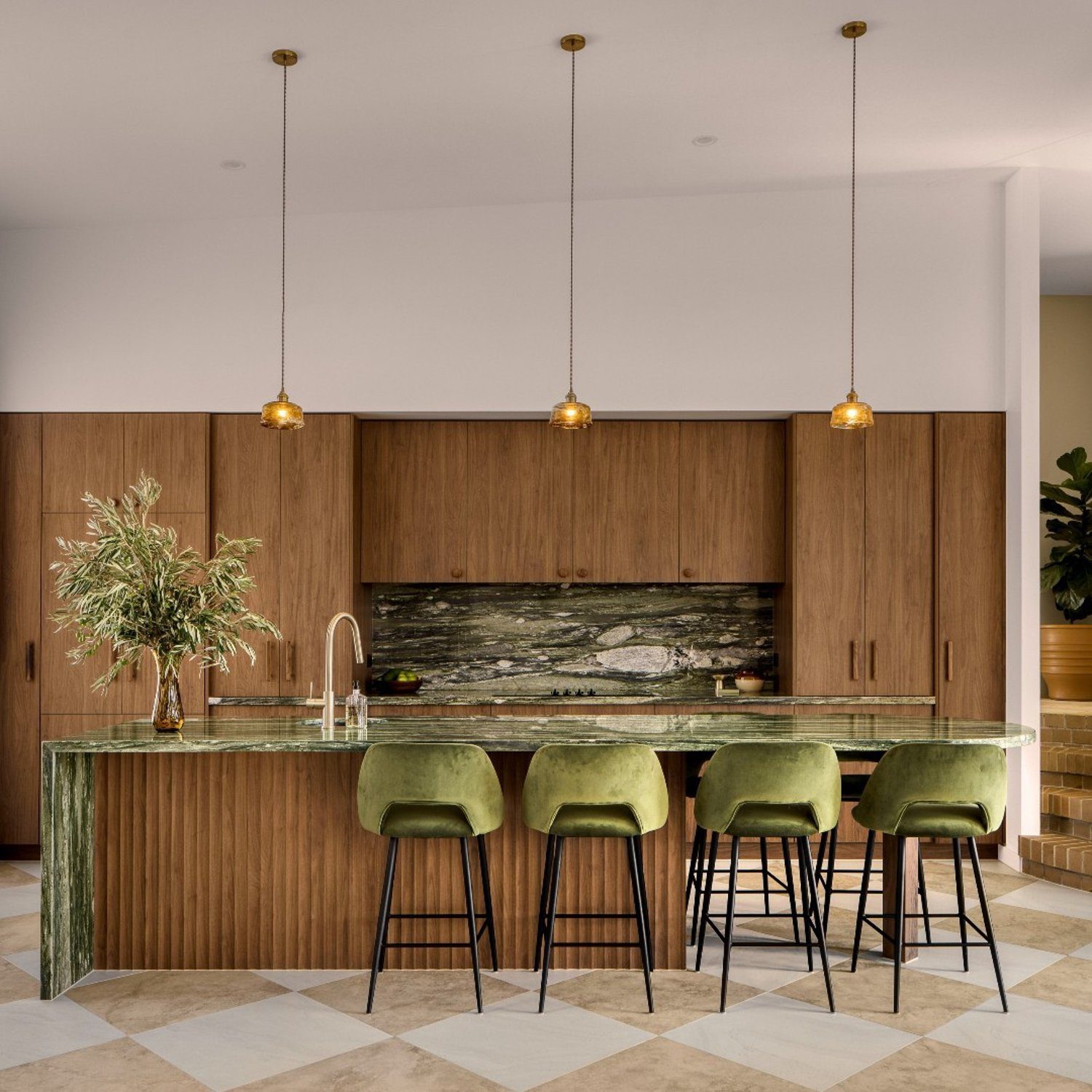 Elegant modern kitchen with wooden cabinetry and velvet green bar stools