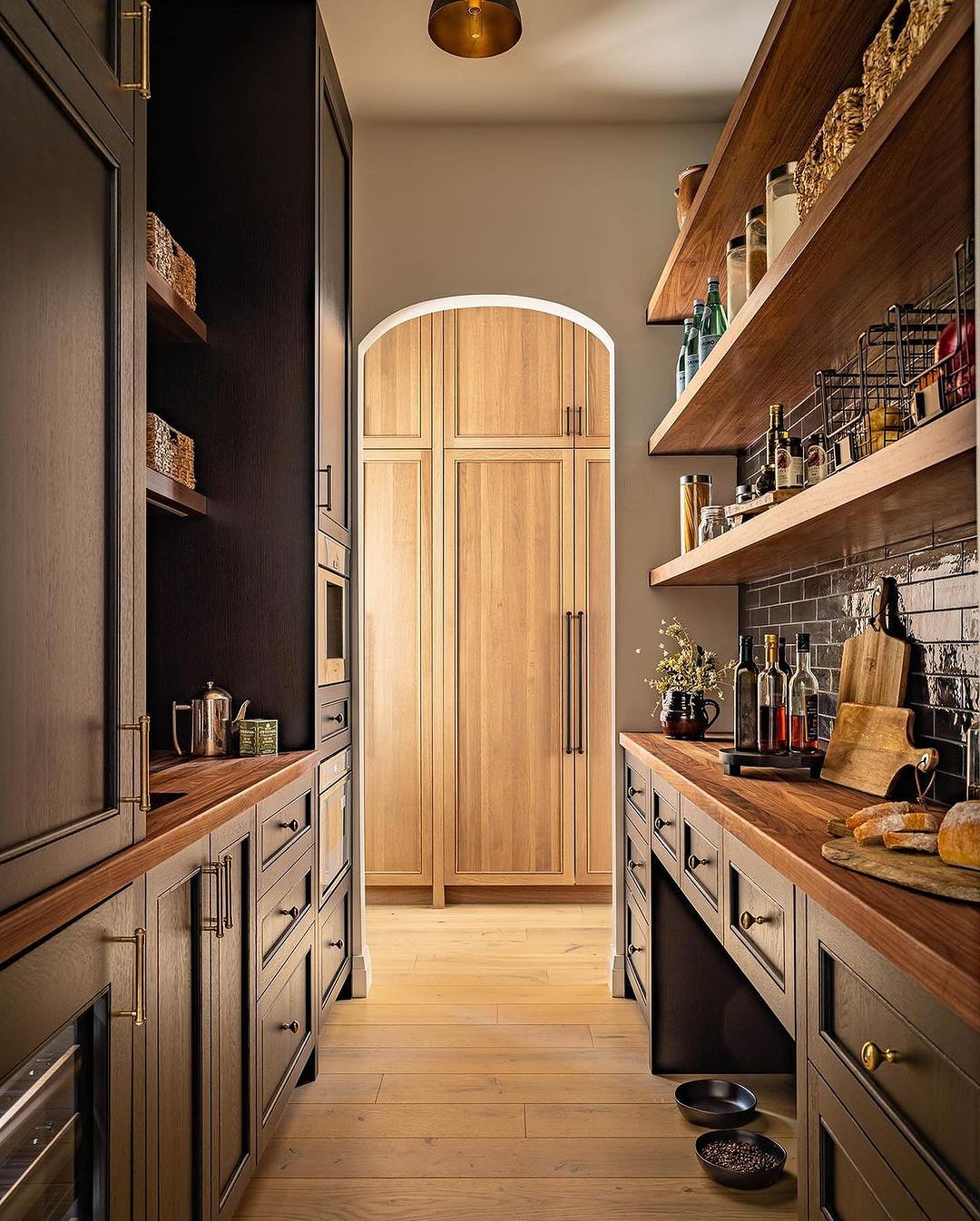 A well-organized kitchen with warm wood tones and dark cabinetry