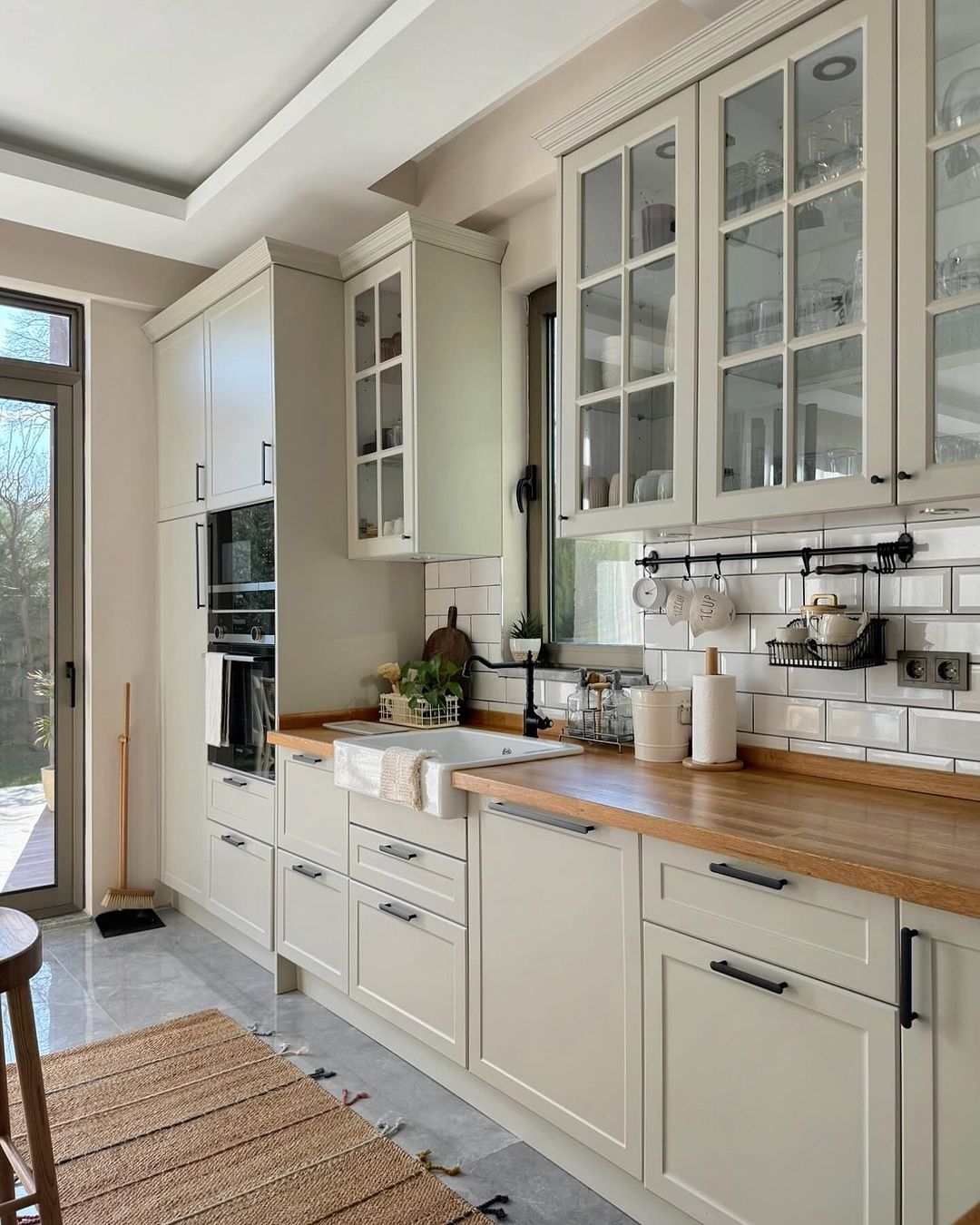 A modern kitchen featuring cream-colored cabinetry and a large farmhouse sink