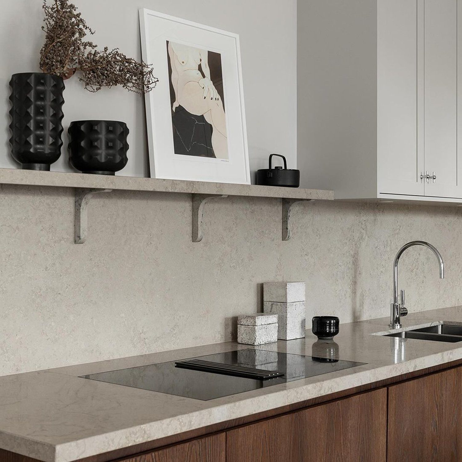 A sleek minimalist kitchen featuring a warm wooden cabinet with seamless handles, stone countertops, and an unobtrusive backsplash.