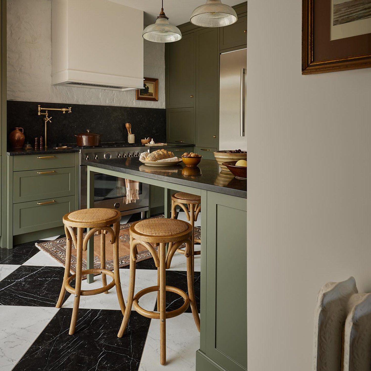 Elegantly designed kitchen with green cabinetry and marble countertops