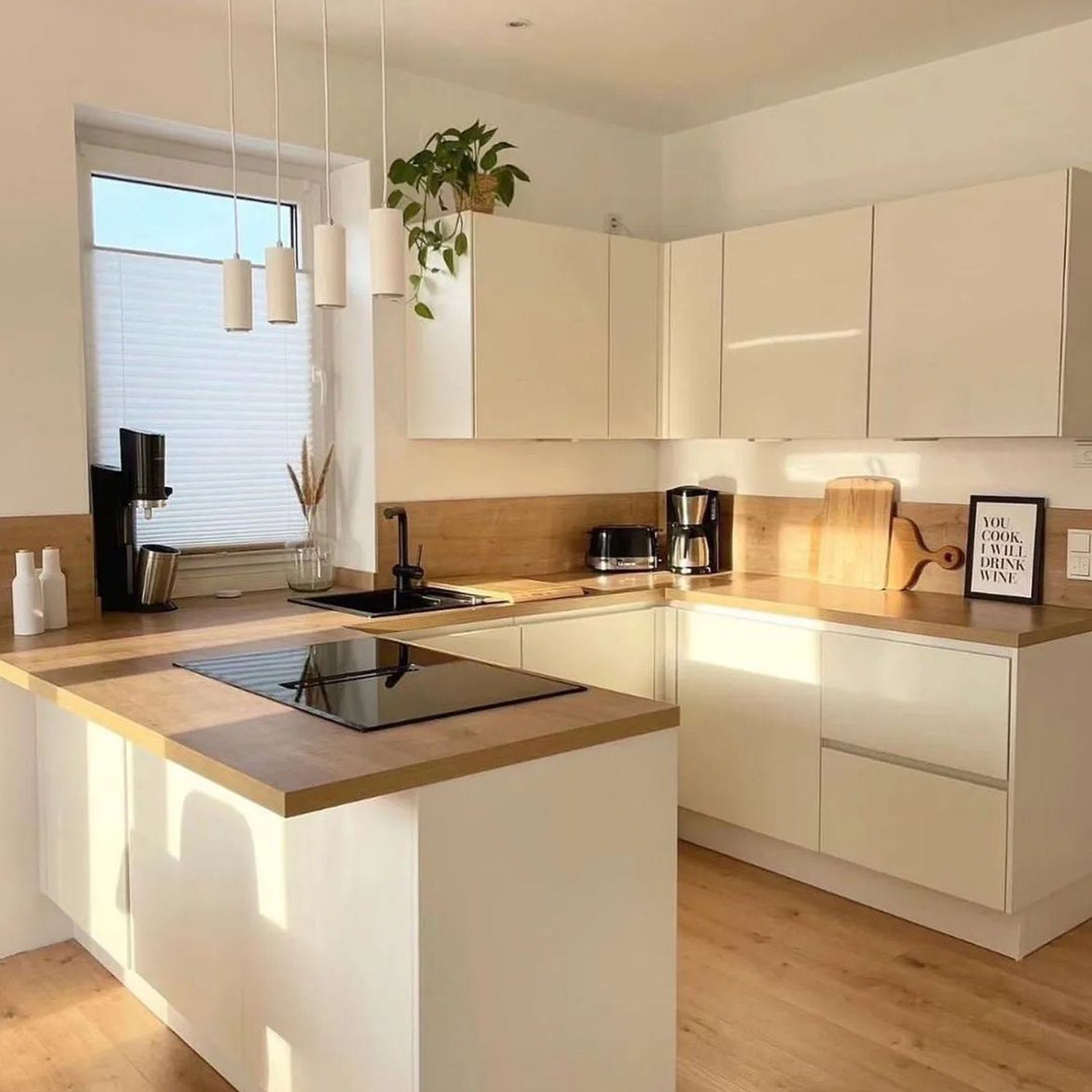 A modern kitchen with white cabinetry and a wooden countertop island