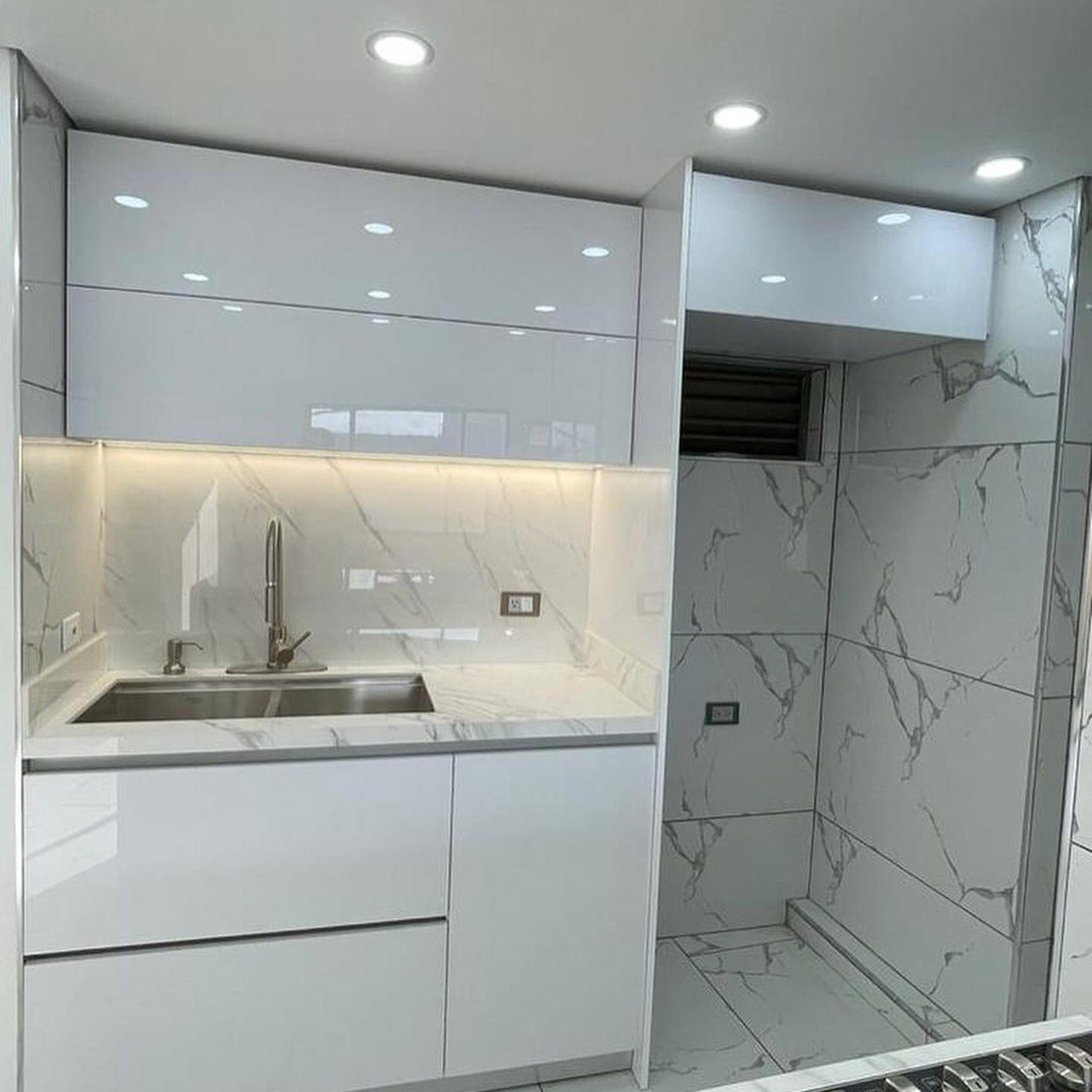 A sleek and modern kitchen with glossy finishes and marble effects