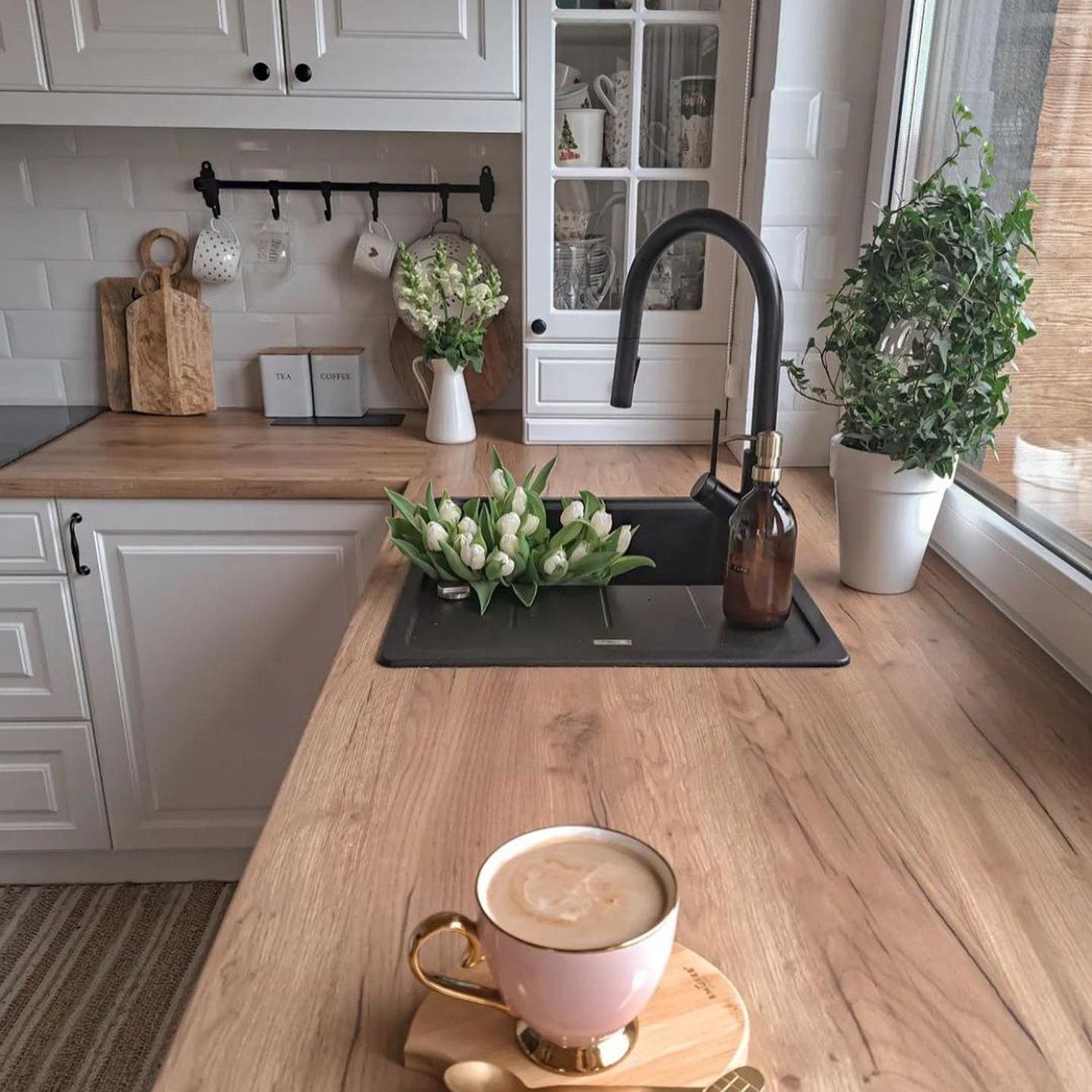 A modern kitchen design incorporating natural wood elements and white cabinetry.