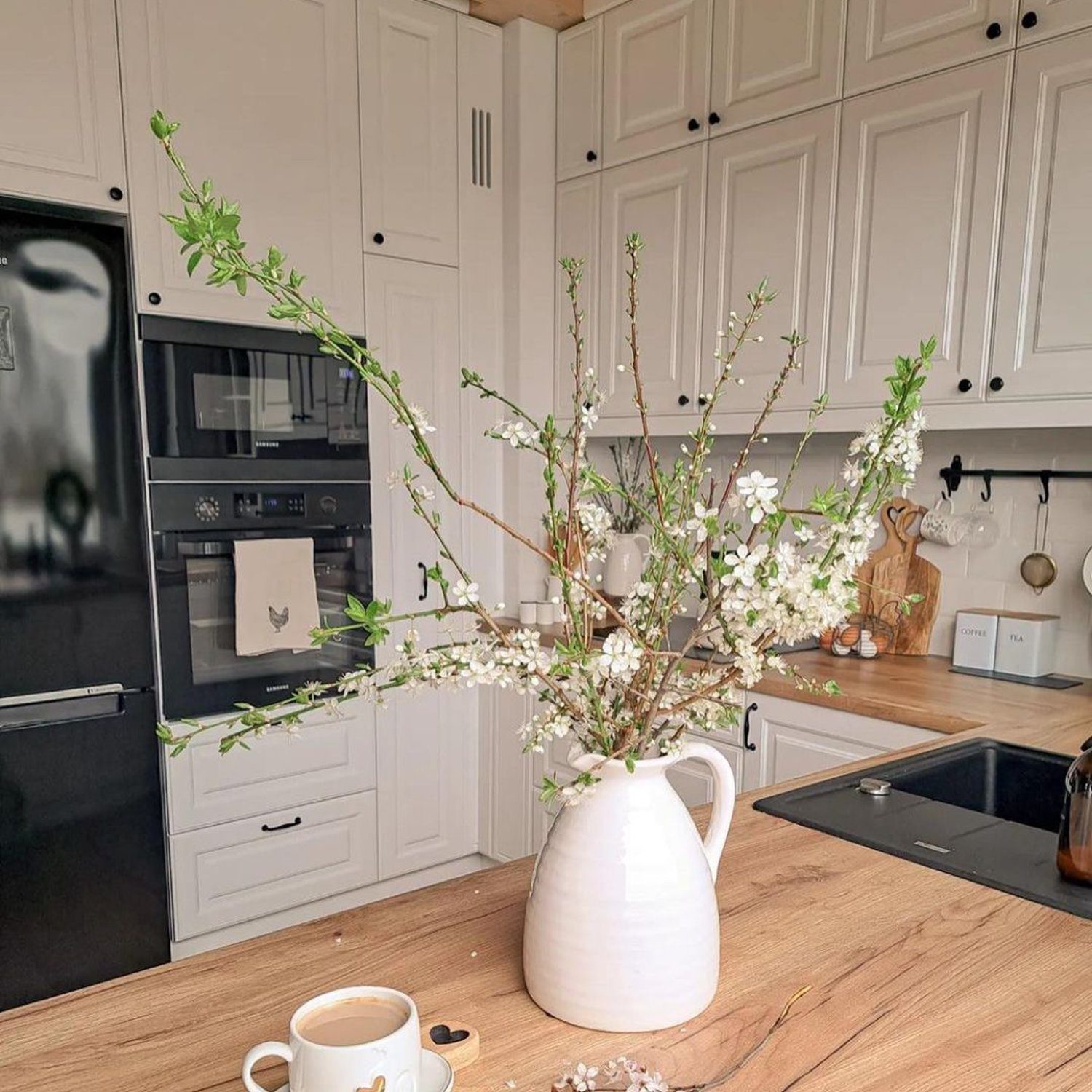 A harmoniously designed modern kitchen space with white cabinetry and warm wooden accents.