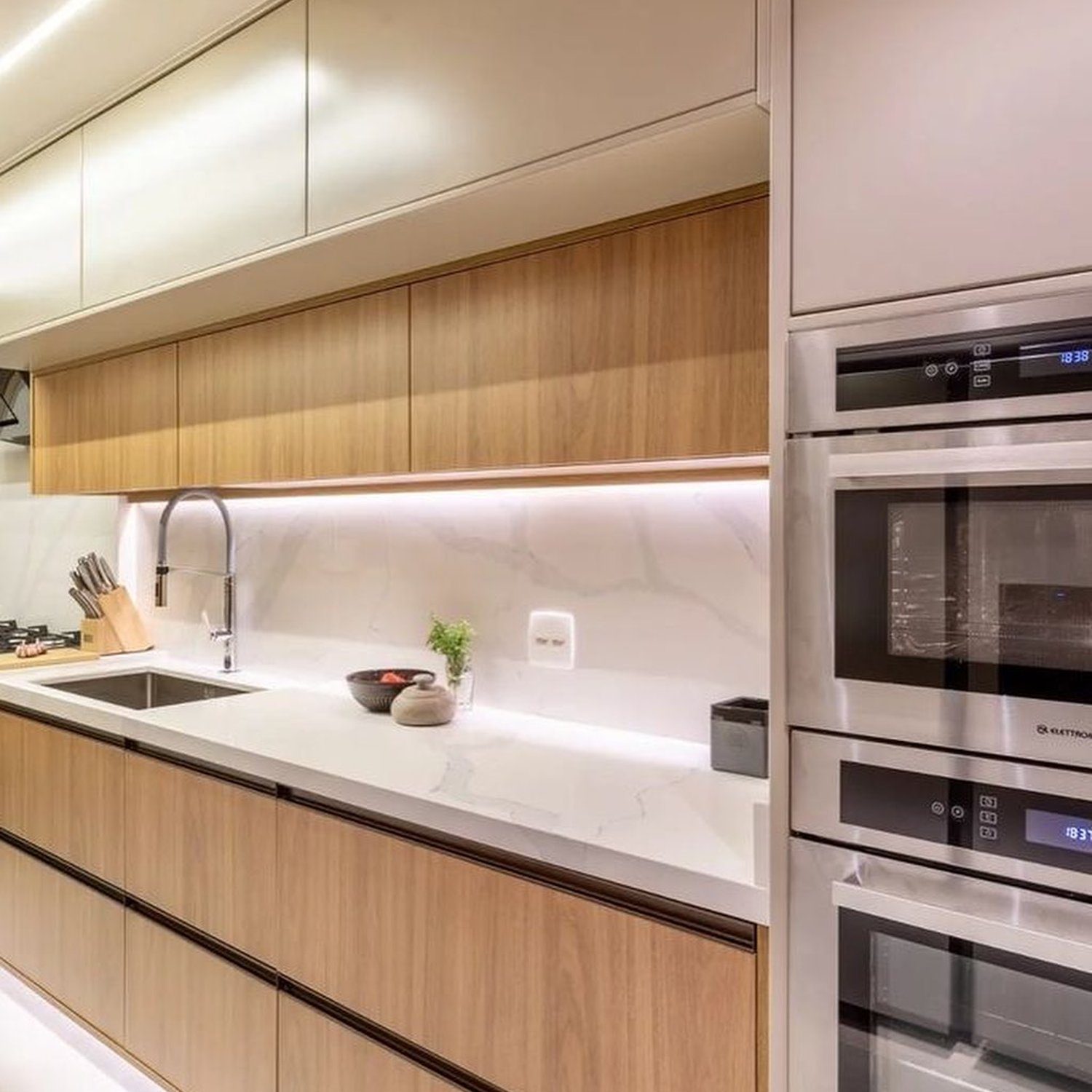 A modern kitchen with wood accents and built-in appliances