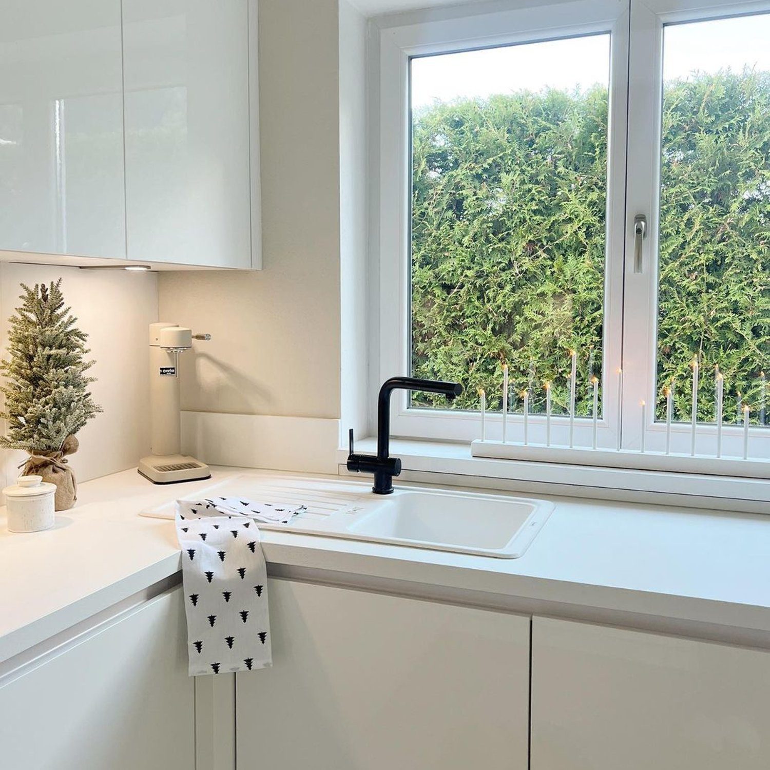 A modern kitchen with a window overlooking greenery