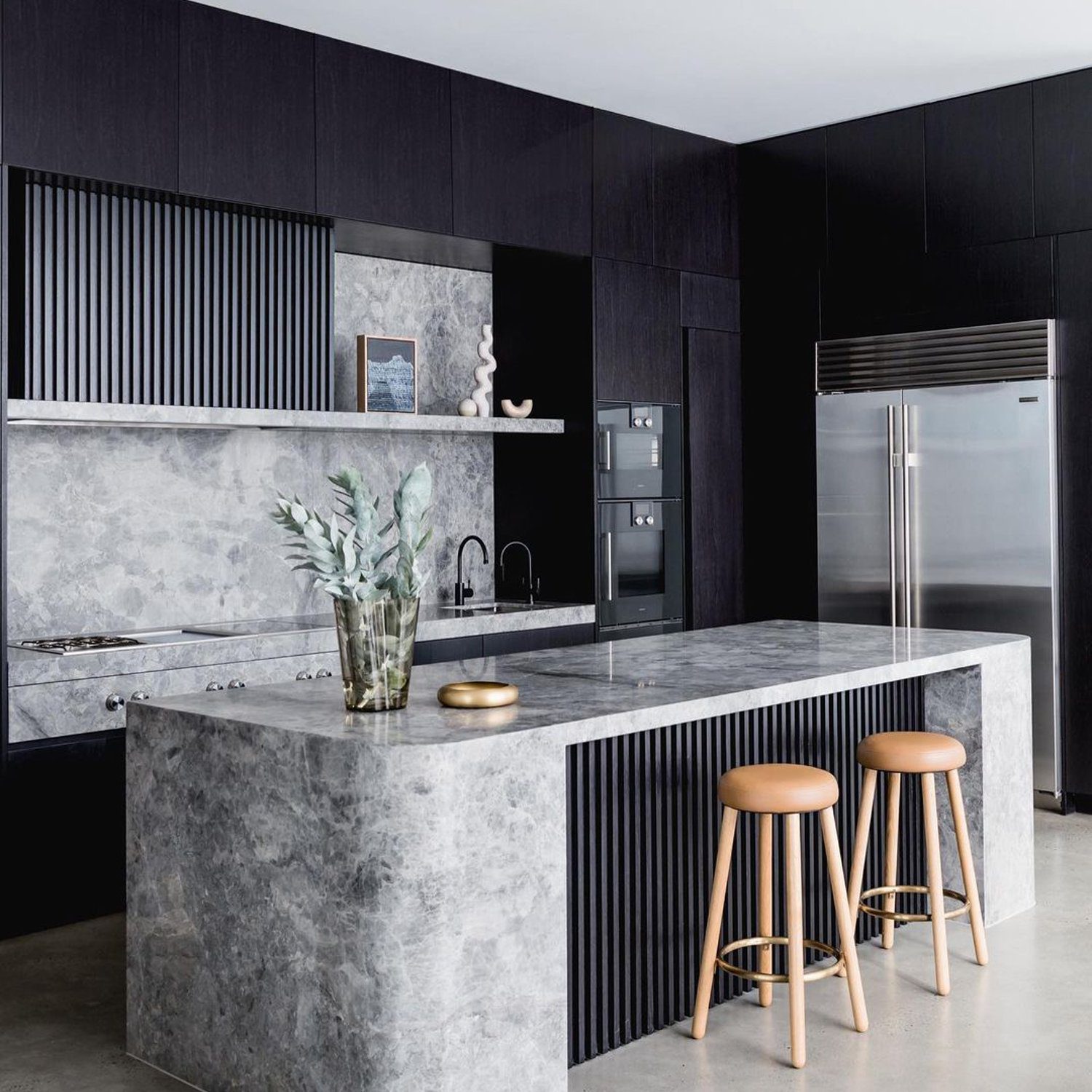 A modern kitchen with dark wood cabinetry and marble accents