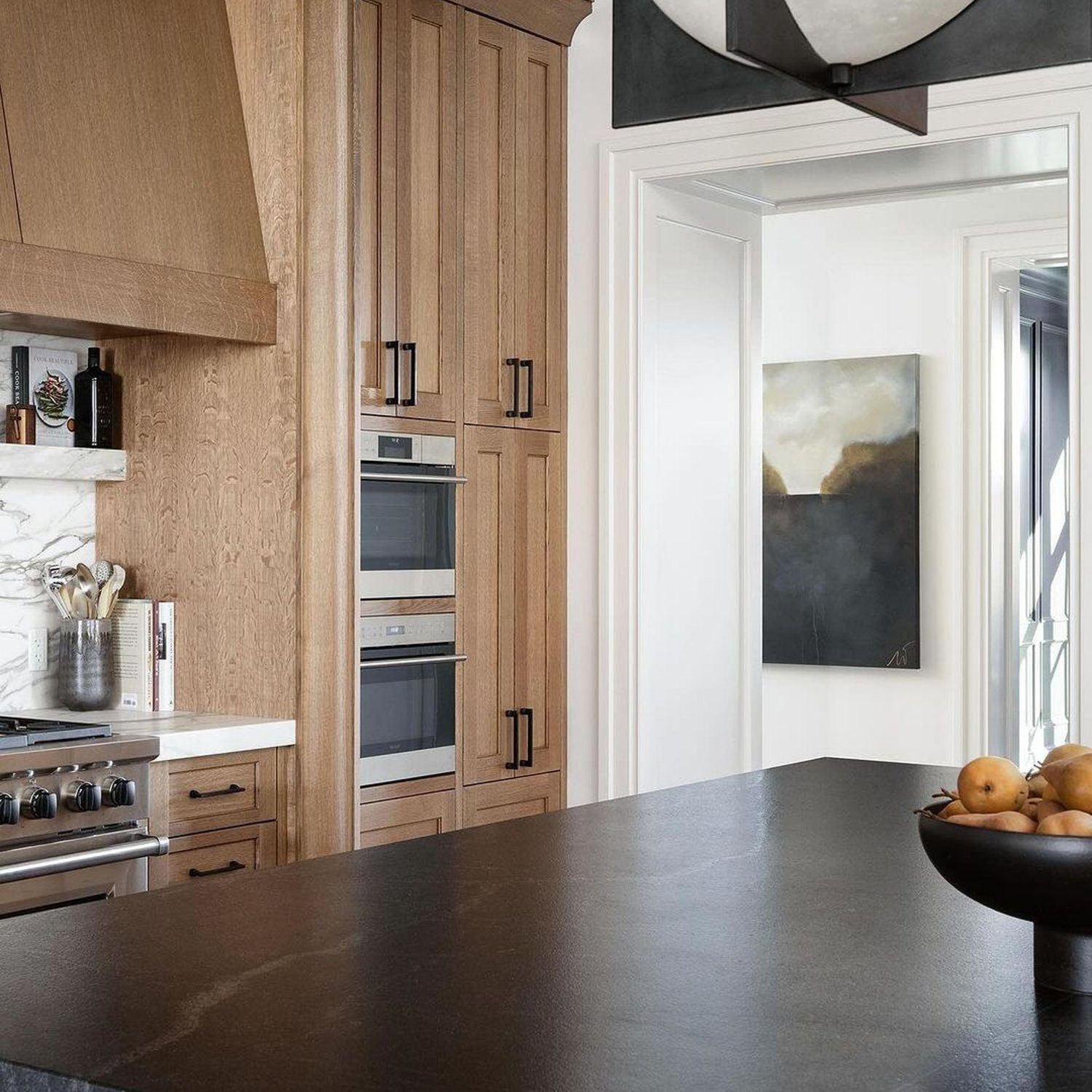 Elegantly designed kitchen featuring natural wood cabinets and dark countertops