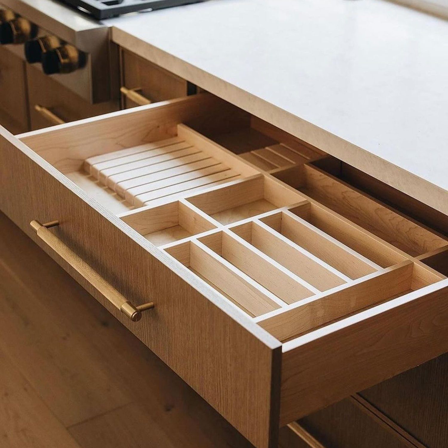 A neatly organized kitchen drawer with customized wooden dividers