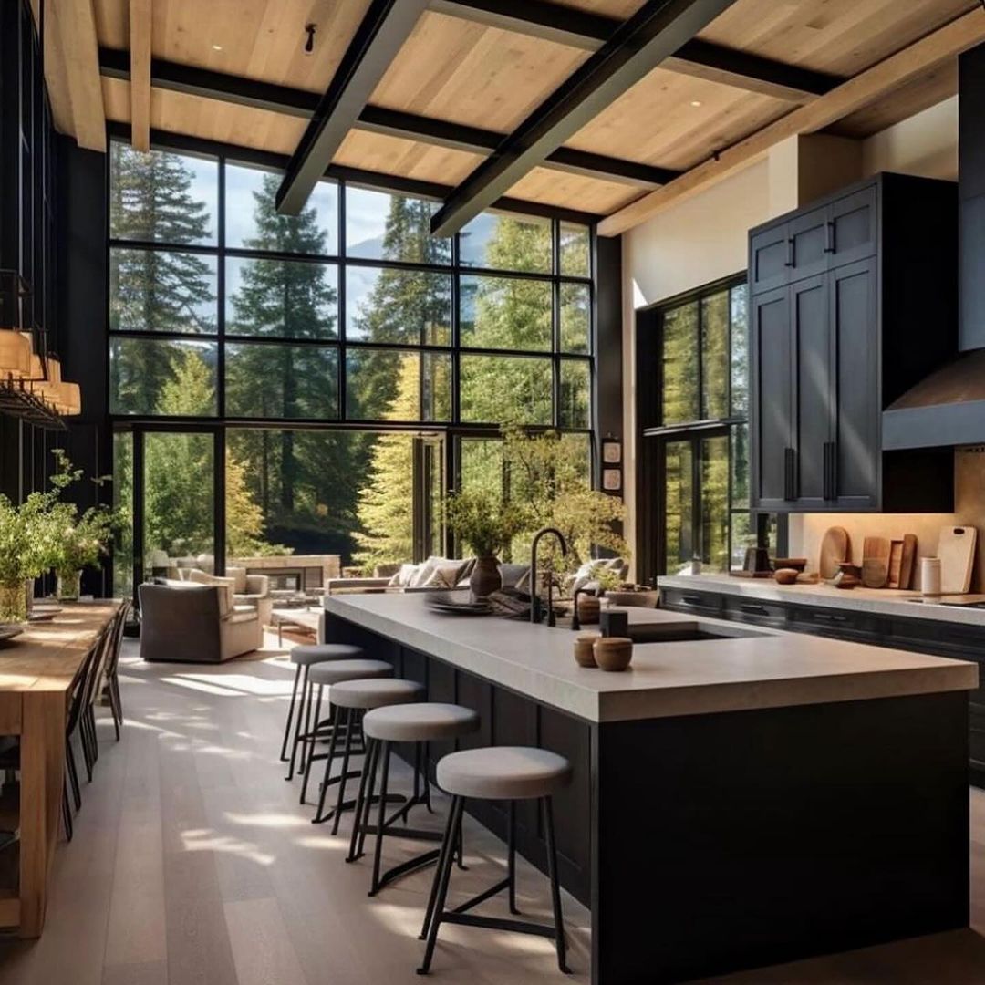 Modern kitchen with large windows overlooking a forest