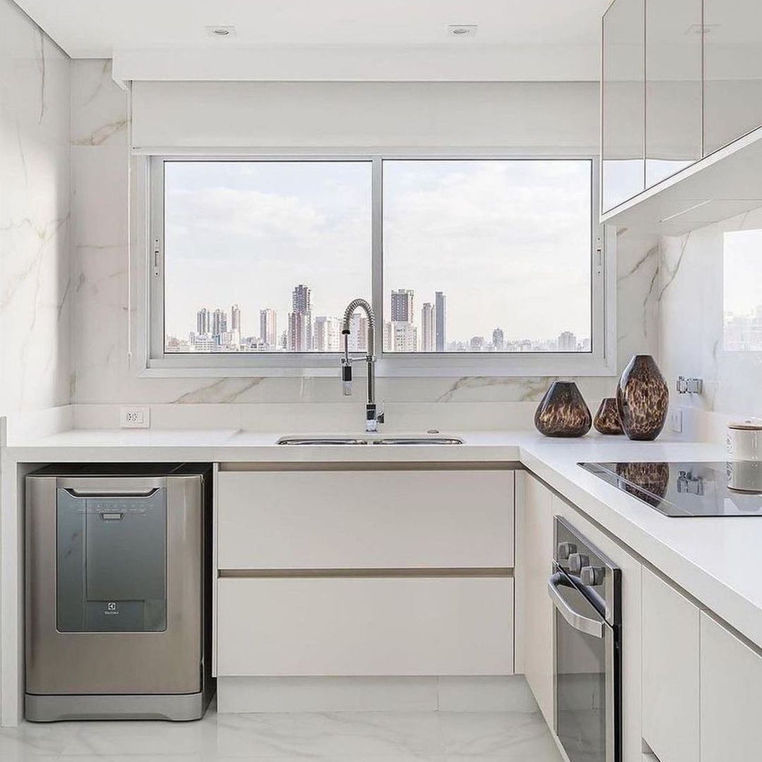 A modern kitchen with marble details, showcasing a sleek design with city views