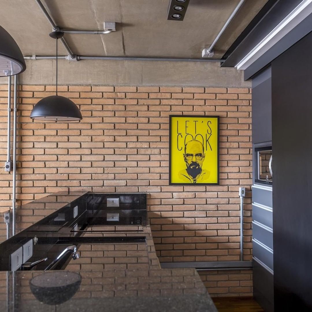 A modern kitchen with exposed brick walls