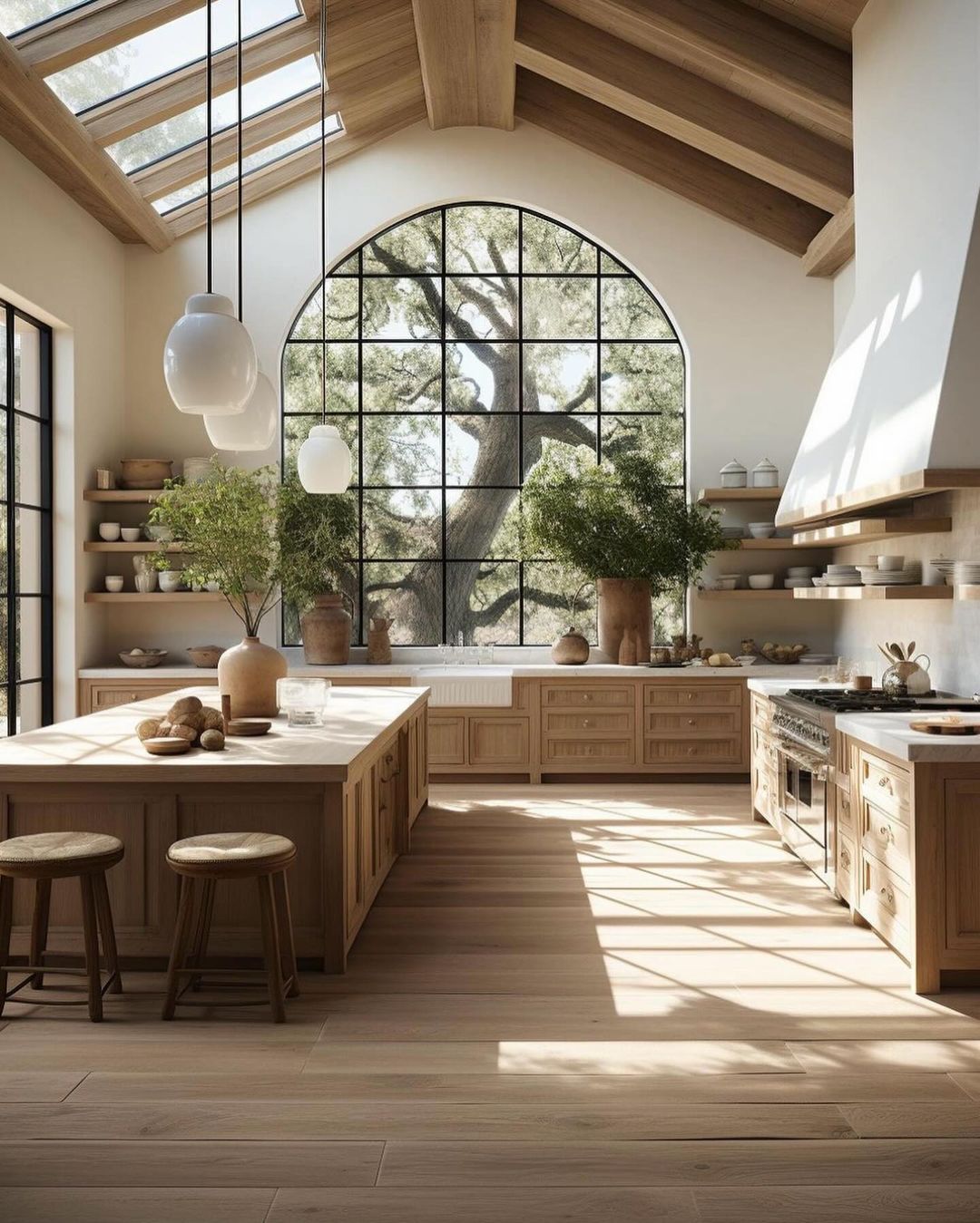 A bright and spacious kitchen featuring an arched window with a view of trees