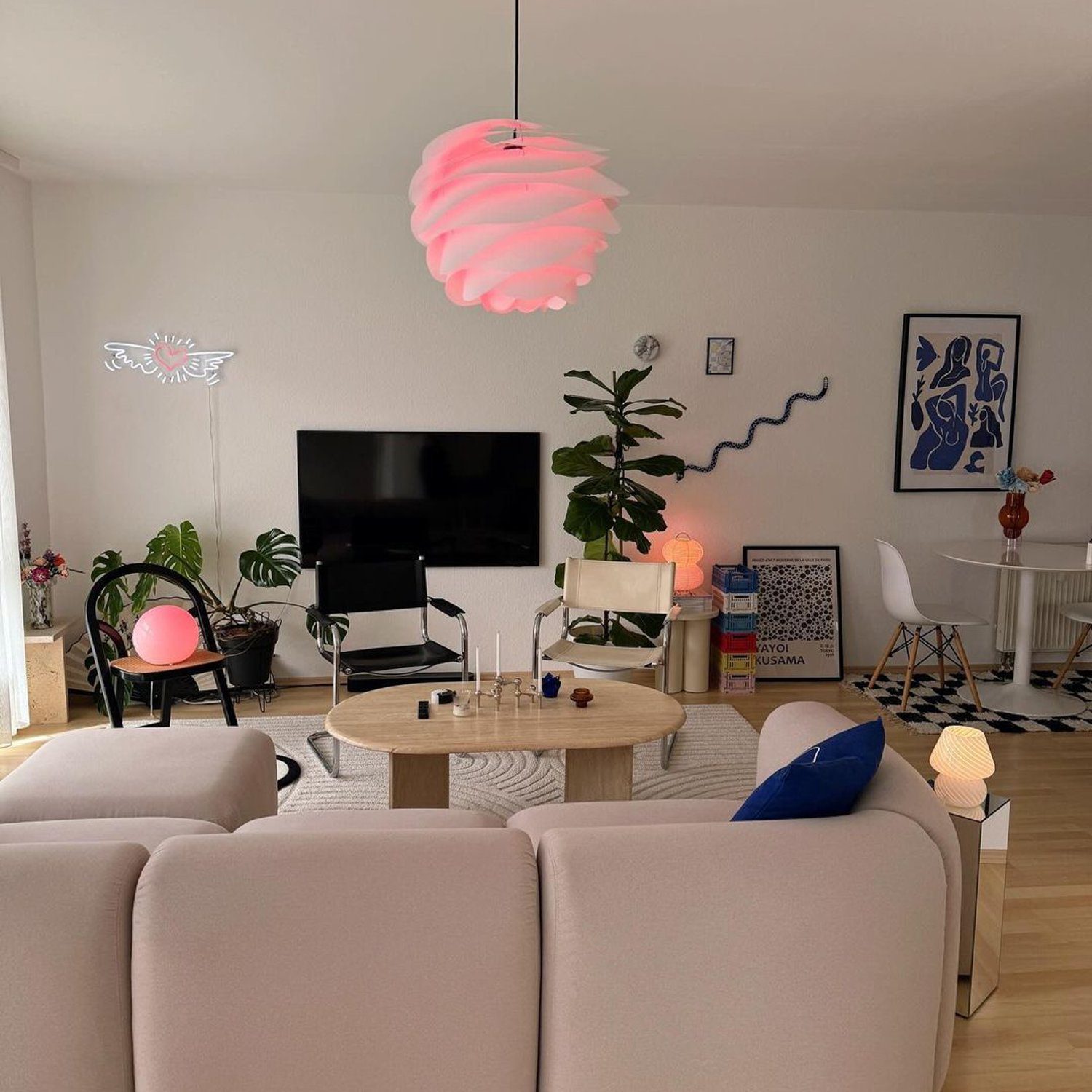 A modern and stylish living room with a unique pink layered pendant light