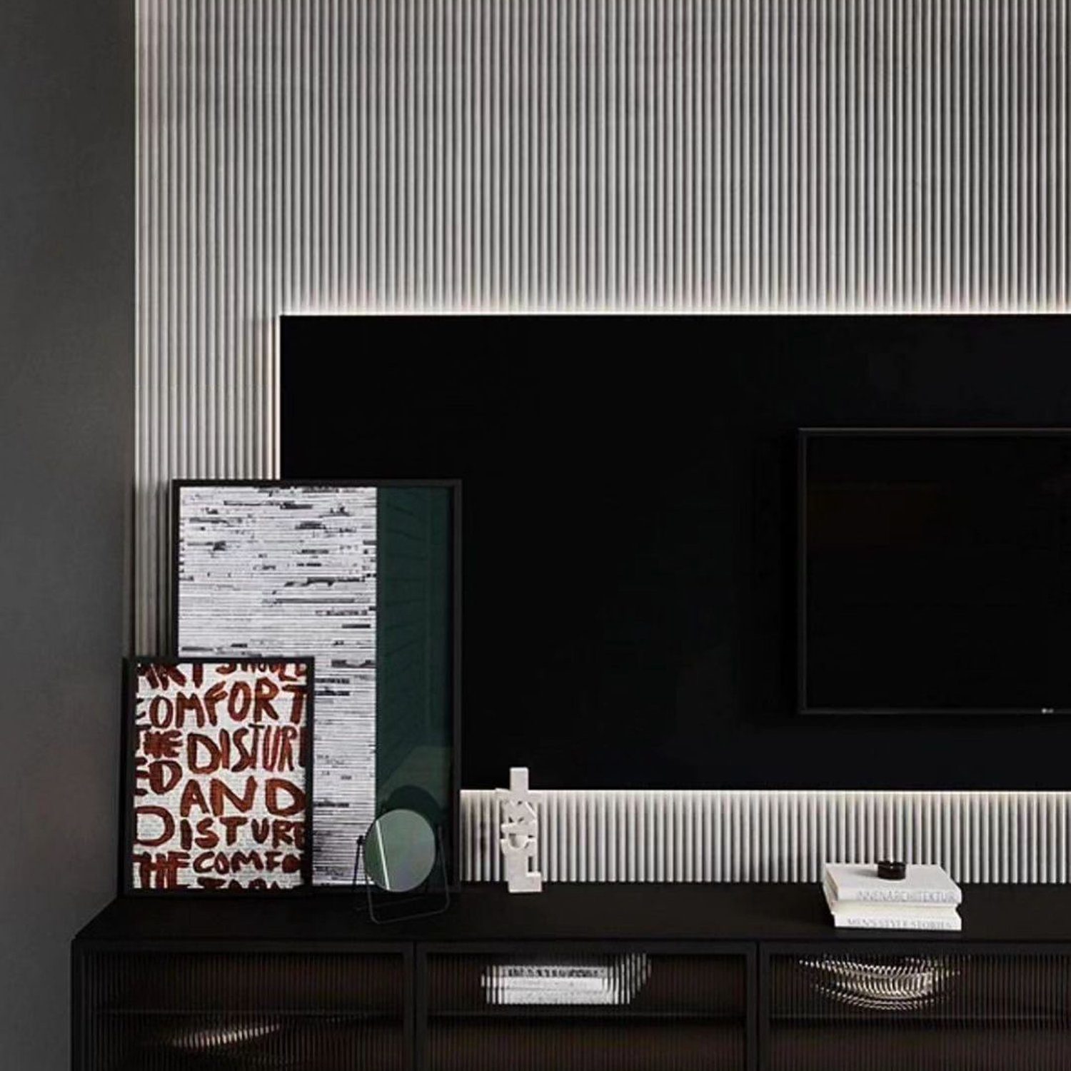 A minimalist and modern living room featuring a dark-toned entertainment center with a fluted feature wall