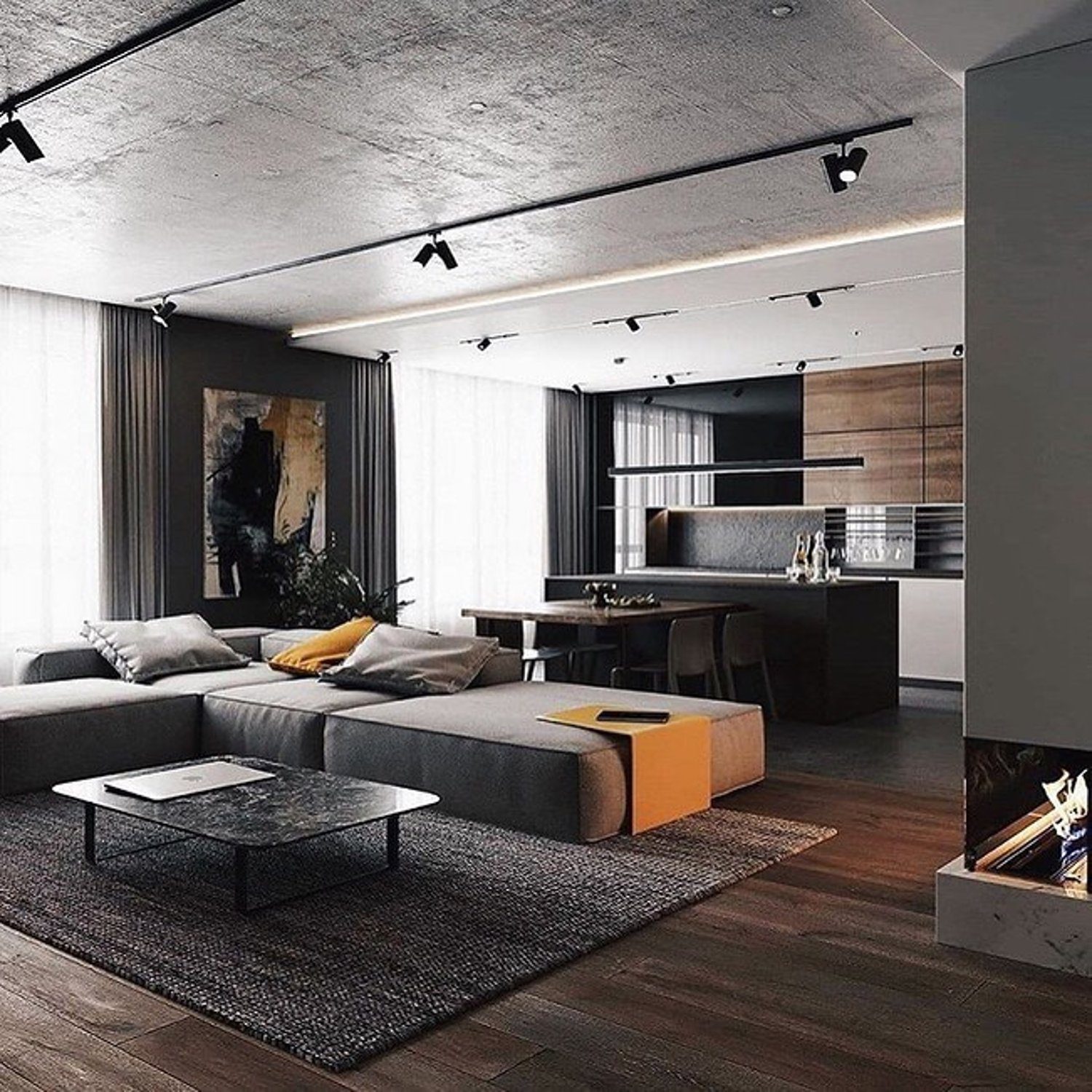 Stylish modern living room with integrated kitchen that features a muted color palette, exposed concrete ceiling, and sleek contemporary furniture.