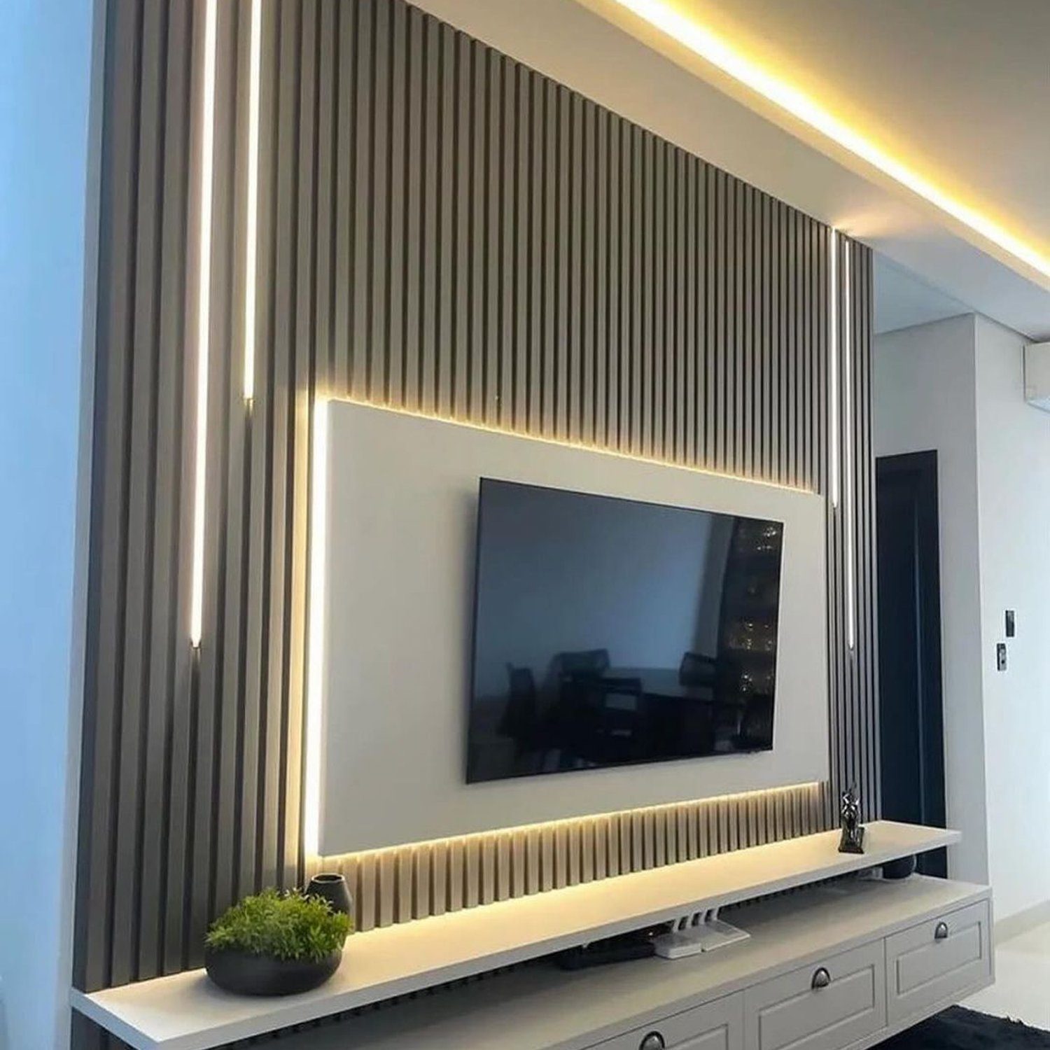 Elegant and modern living room featuring a wall-mounted TV surrounded by vertical lighting strips