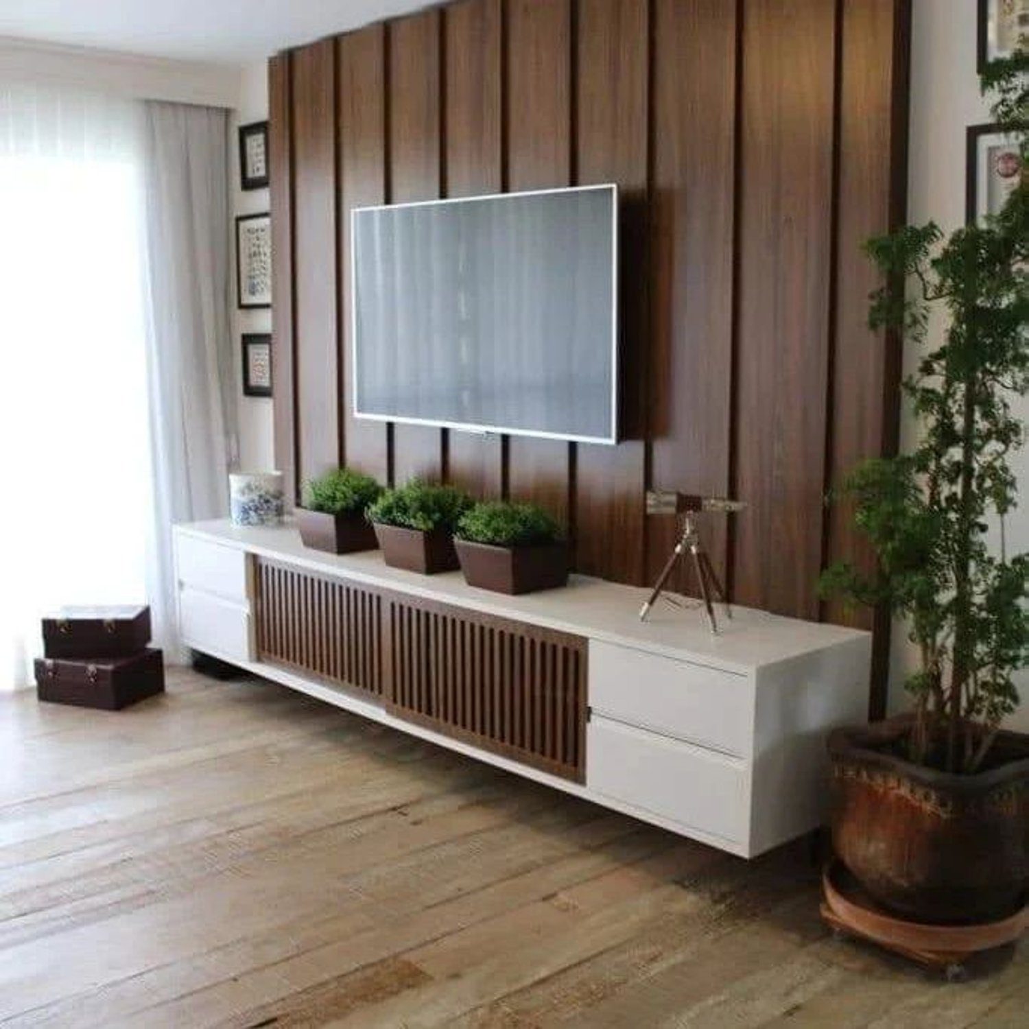 Modern living room design with sleek white entertainment unit and warm wood paneling