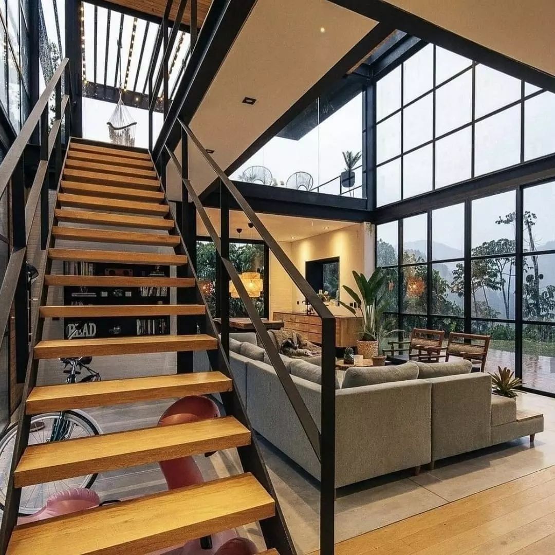 Modern industrial-style loft with expansive windows and a cozy living area