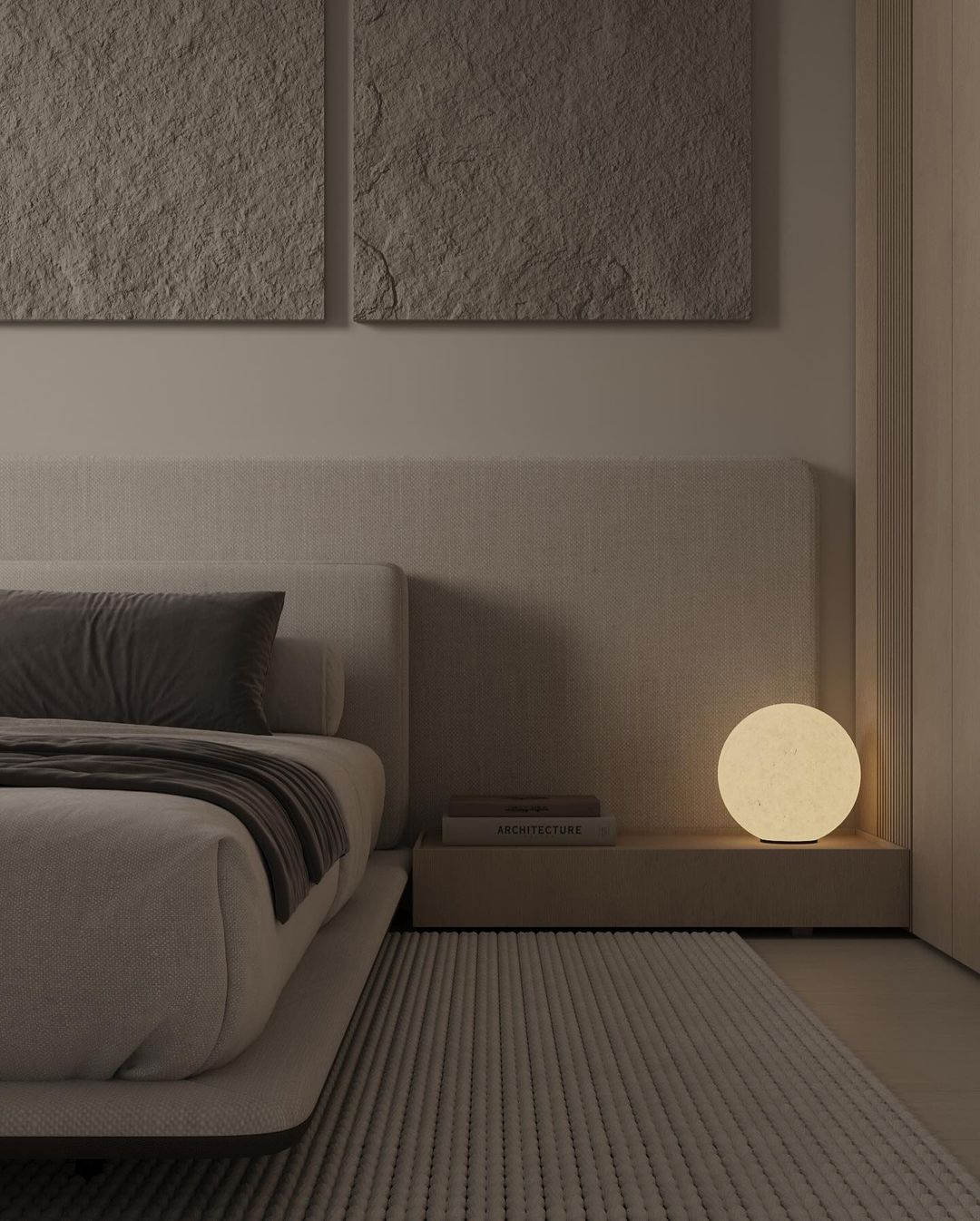 A minimalist bedroom design featuring a clean-lined beige bed, textured beige walls, and a spherical table lamp