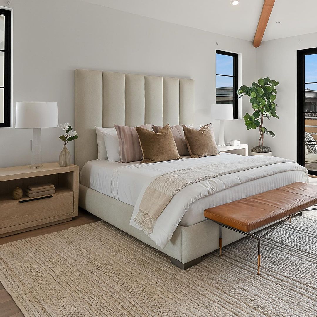 A minimalist bedroom featuring a large paneled headboard