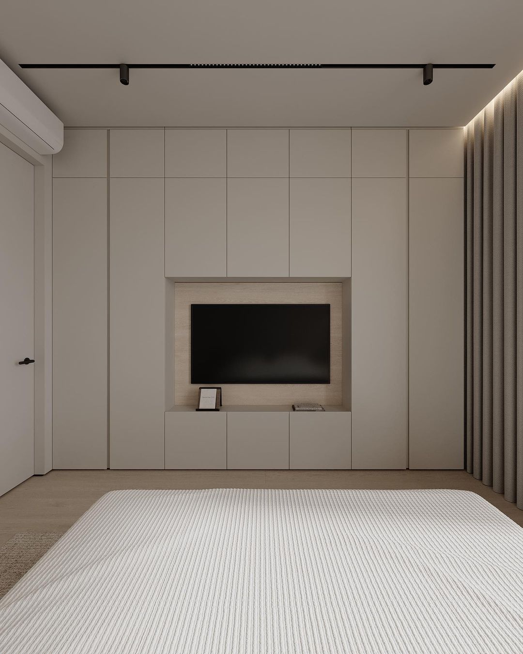 A minimalist bedroom featuring a sleek built-in wall unit with storage and a recessed TV nook