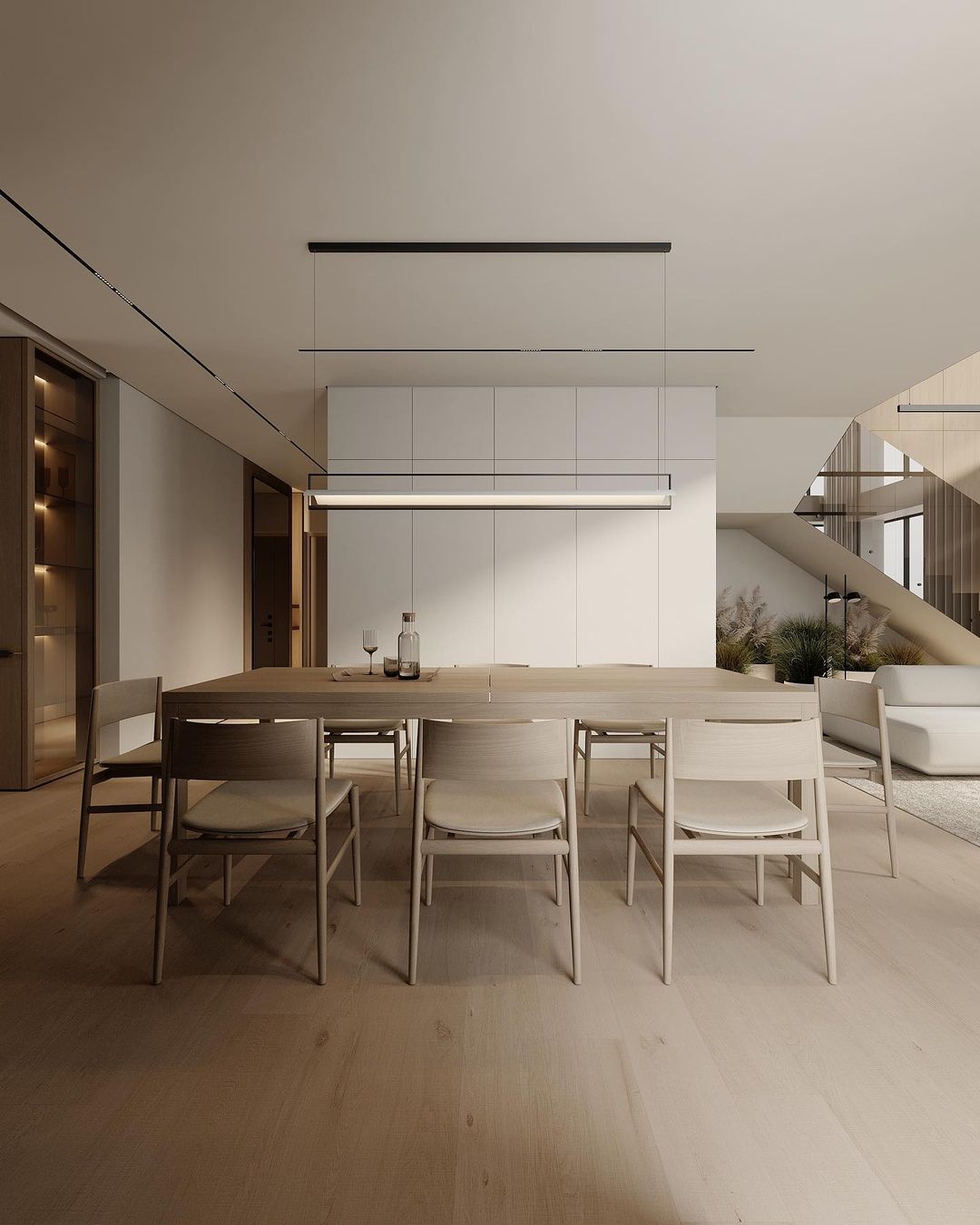 A modern minimalist dining area with light wood tones and simple furniture