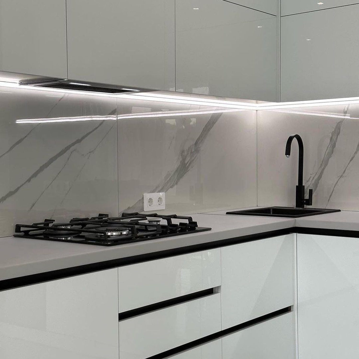 A sleek and minimalist kitchen with a marble backsplash