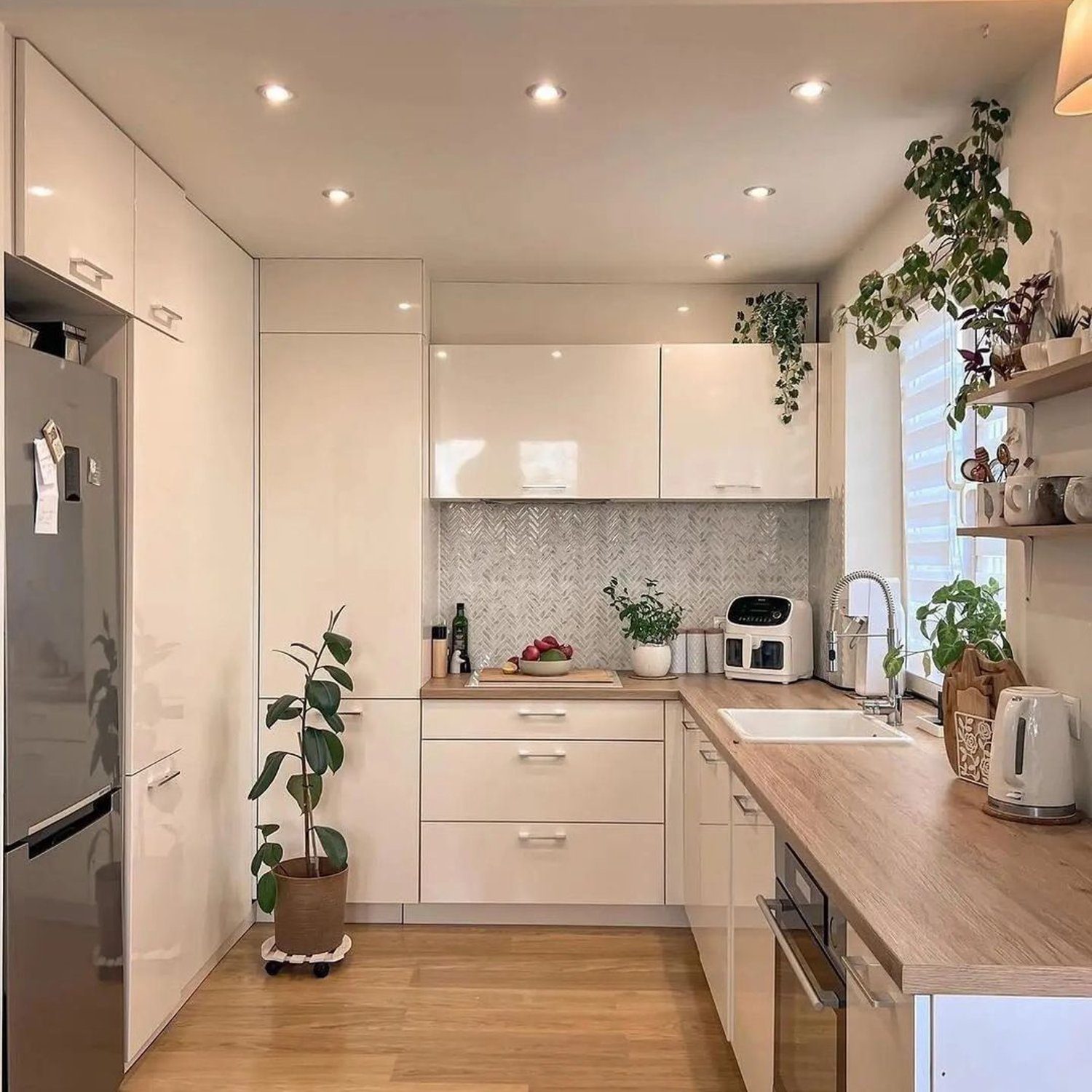 A modern, minimalist kitchen with wooden floors and plenty of natural light