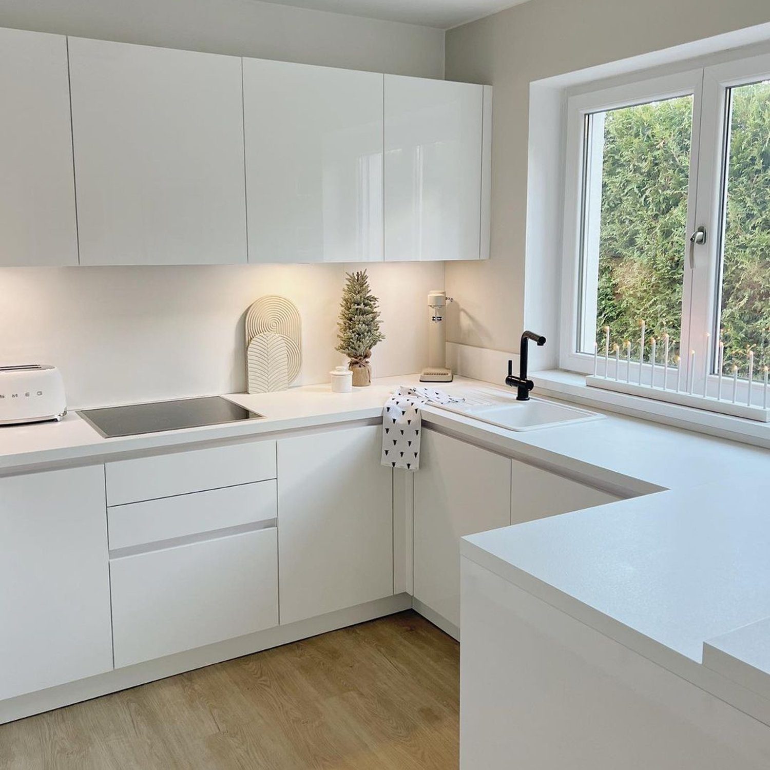 A minimalist kitchen with white cabinetry and modern design