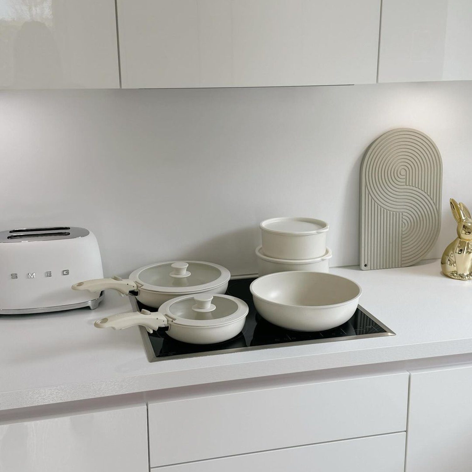 A minimalist kitchen with sleek white cabinetry and modern appliances