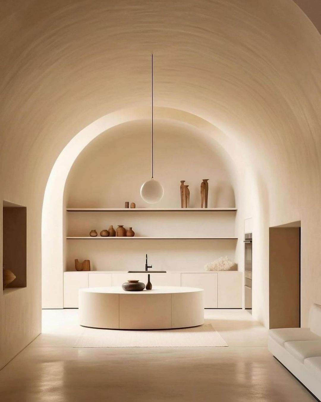 A modern minimalist kitchen with arched ceilings and a central island