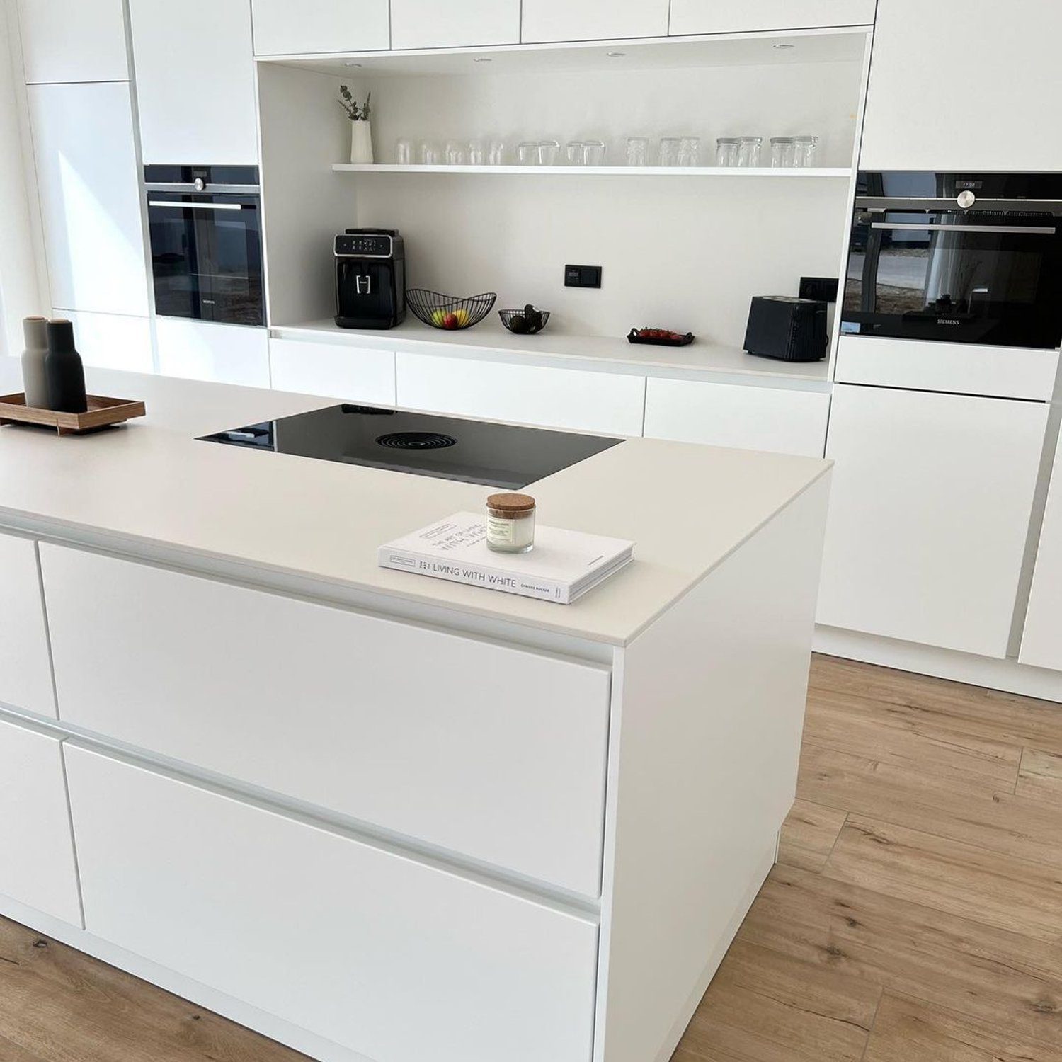 A minimalist kitchen with sleek white cabinetry and modern appliances