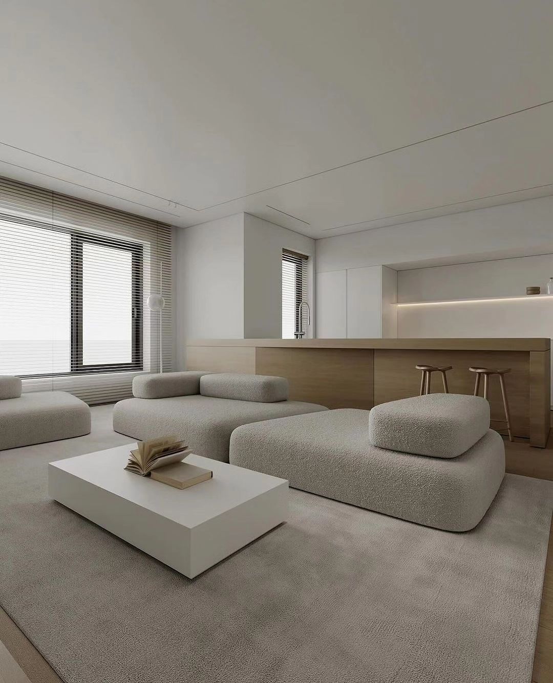 A modern minimalist living room with soft contour furniture and blended neutral tones