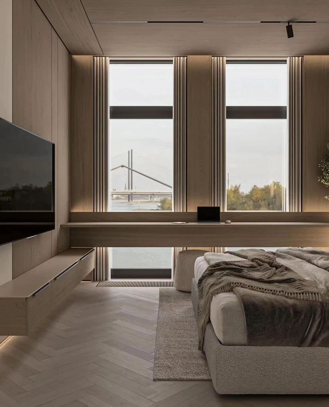 A minimalist living room with large windows overlooking a bridge