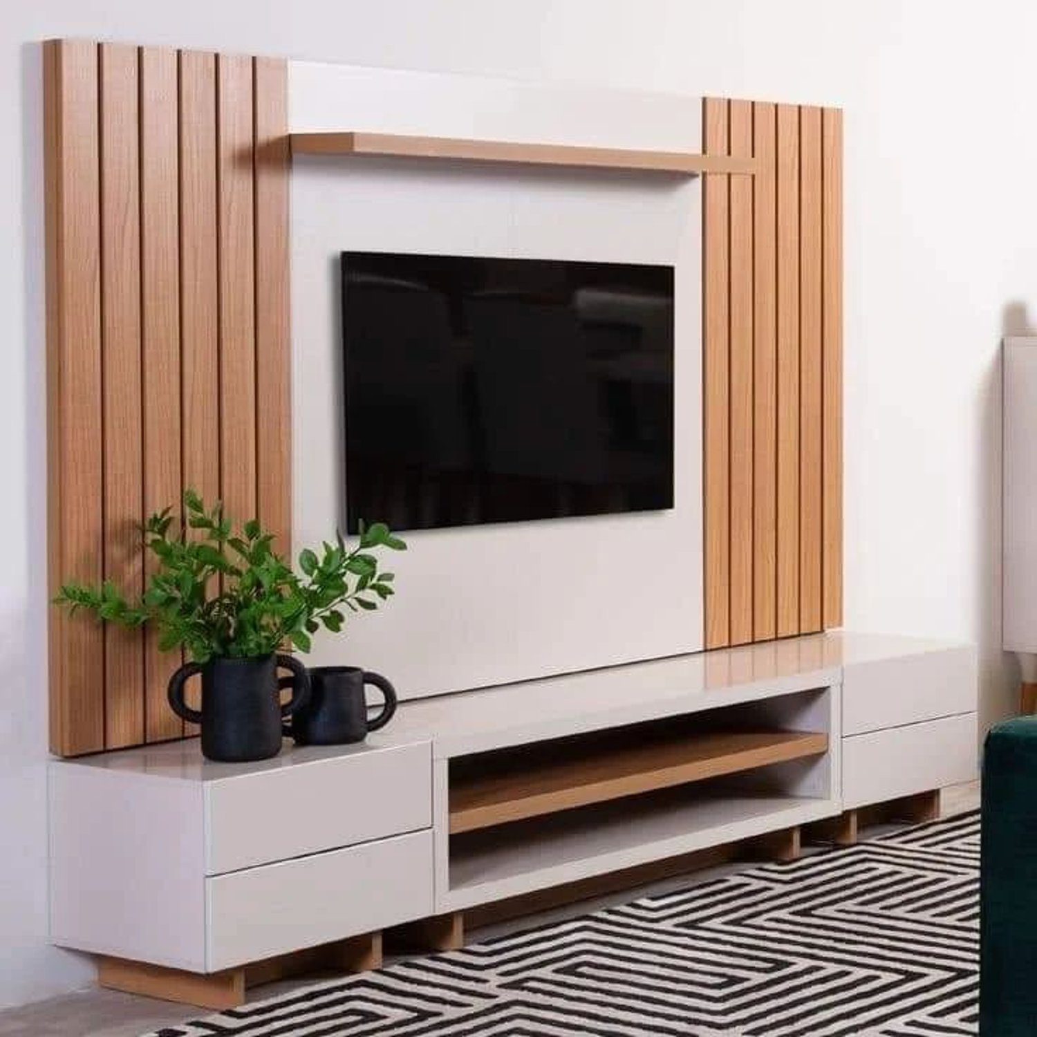 A modern and stylish living room featuring a minimalist white TV stand with natural wood accents, perfectly framing a wall-mounted flat-screen TV.