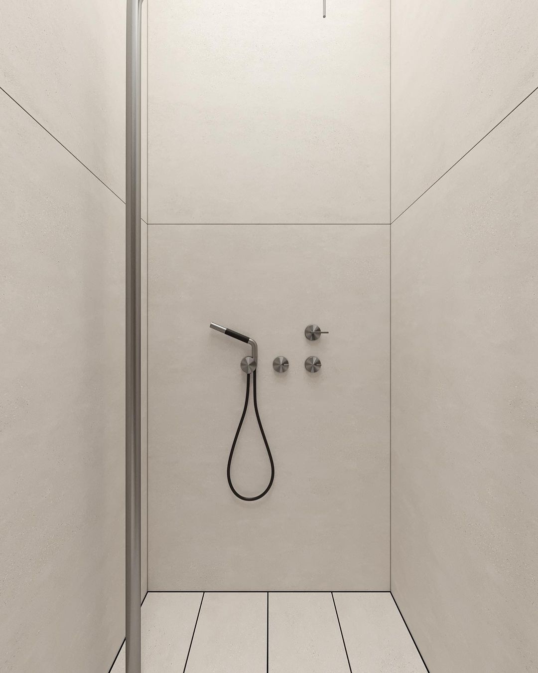 Modern minimalistic bathroom with a wall-mounted hand-held shower, minimal fixtures, and neutral toned tiles