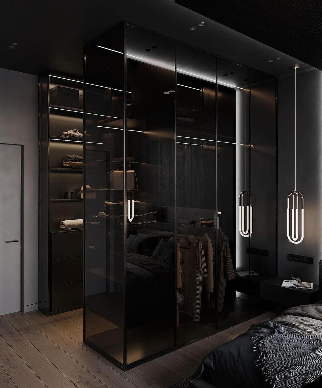 A modern bedroom closet featuring floor-to-ceiling black mirrored doors, ambient lighting, and a sleek design